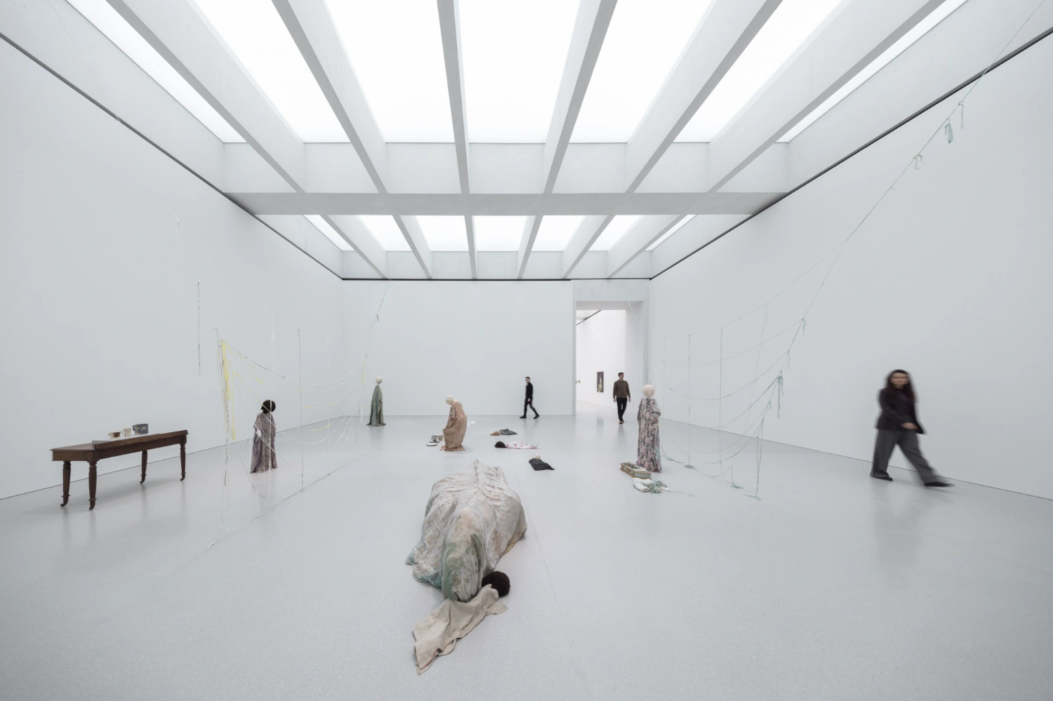 Museum of Modern Art in Warsaw by Thomas Phifer — A vast gallery interior unfolds beneath a coffered concrete ceiling with recessed skylights that distribute even, diffused light across the white polished...