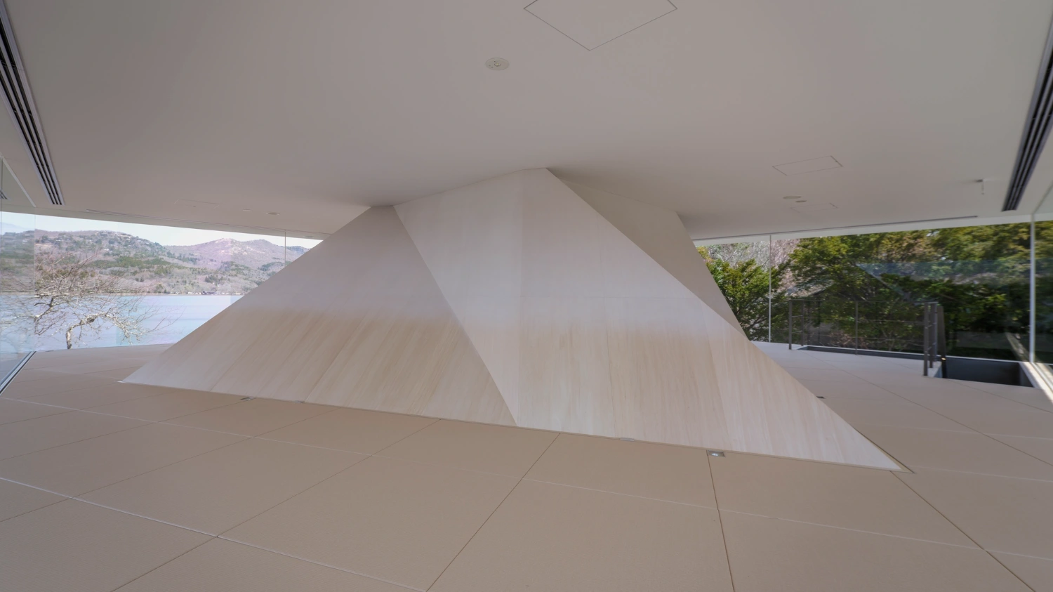 CYCL by YŪ Momoeda Architects — A sculptural white form rises from polished concrete flooring within an open interior volume, its angular surfaces catching diffused natural light from above.