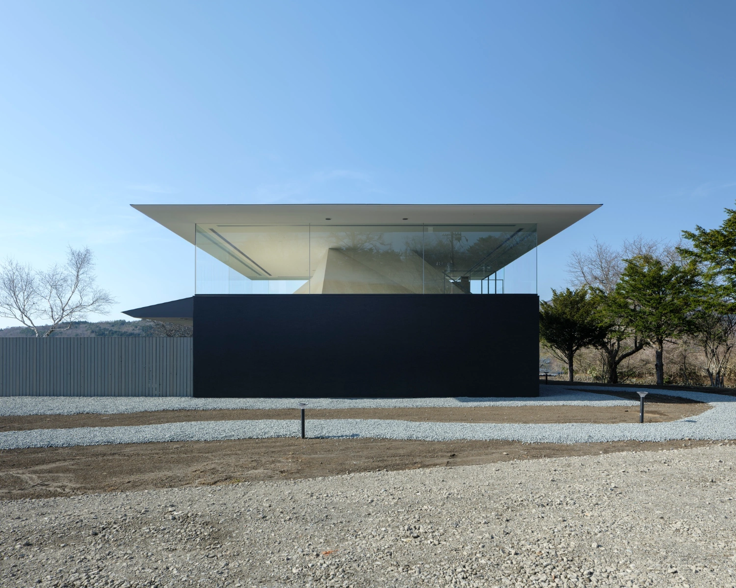 CYCL by YŪ Momoeda Architects — The sauna facility presents itself as a two-tier composition: a cantilevered concrete soffit overhead, its sharp edge cutting horizontally across the frame,...