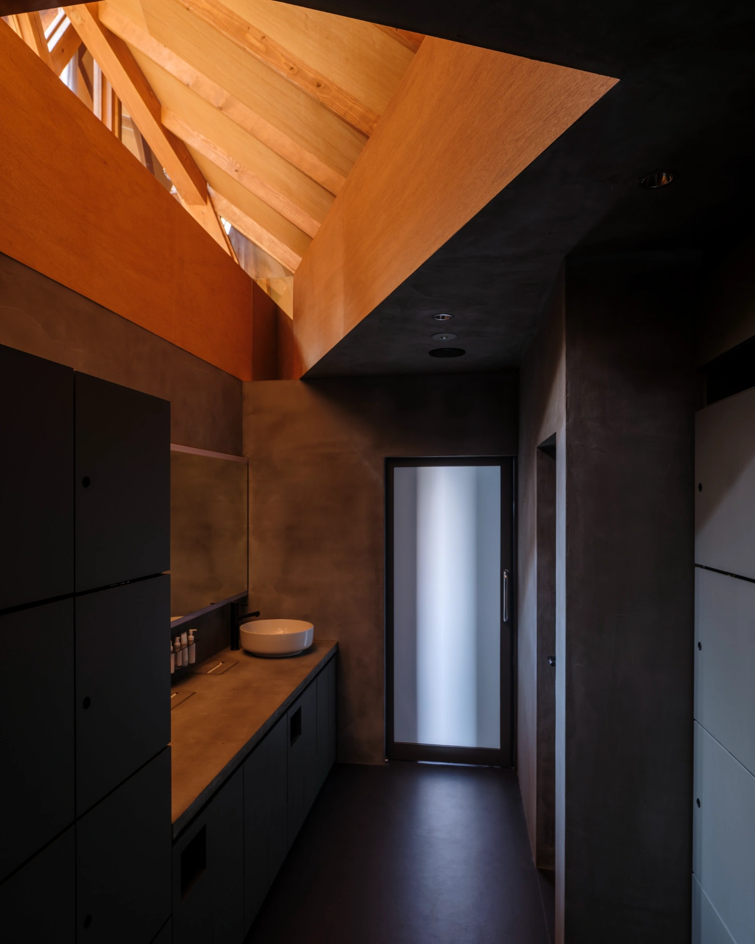 CYCL by YŪ Momoeda Architects — A narrow corridor in CYCL bathhouse features a compressed spatial sequence defined by contrasting materials and light.
