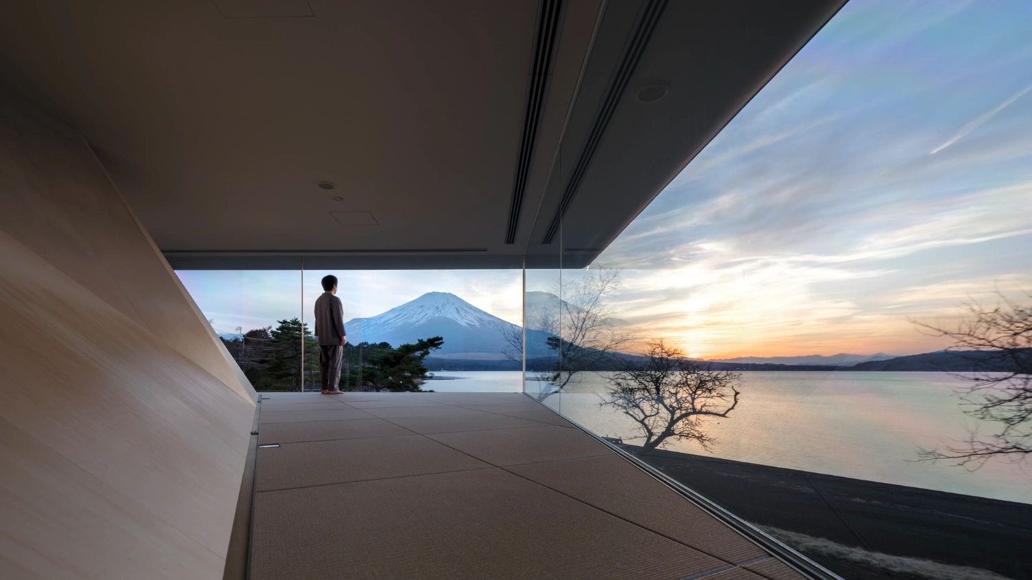 CYCL by YŪ Momoeda Architects — A minimalist interior volume frames Mount Fuji across Lake Yamanaka at dusk.