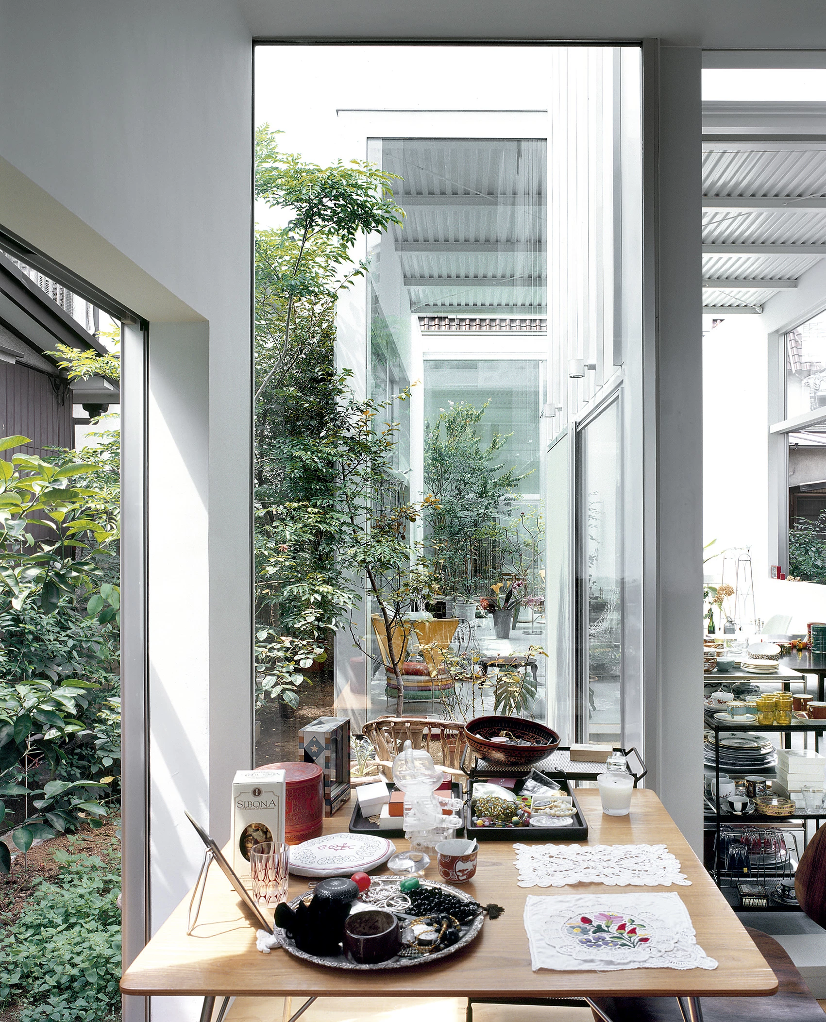 House A by Ryue Nishizawa — A compressed dining threshold framed by floor-to-ceiling glazing reveals the project's spatial strategy.