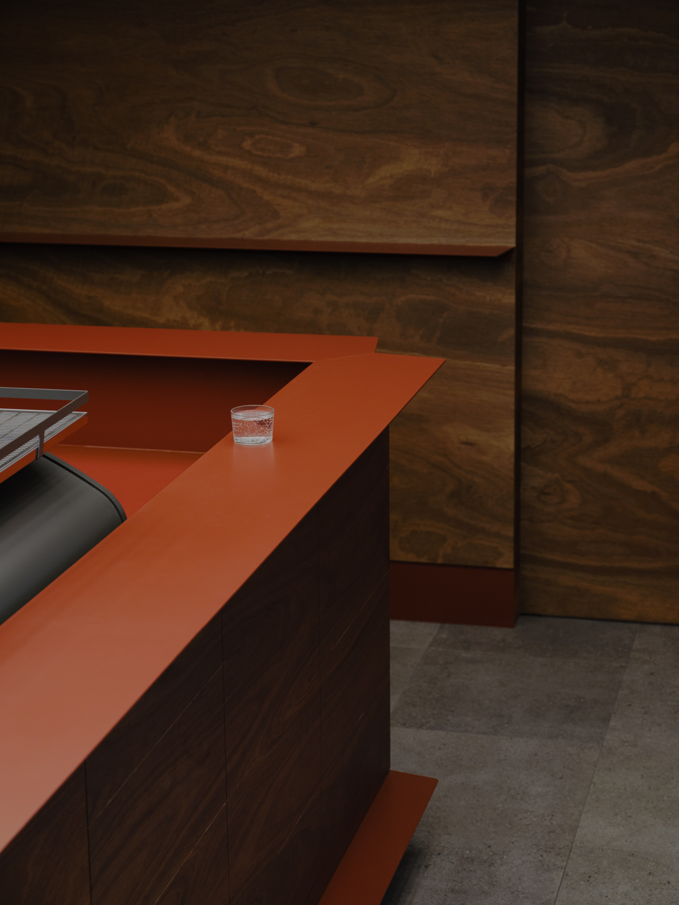 Palace Coffee by KKAP — Interior view of Palace Coffee revealing the oxide-red steel counter surface in sharp focus against recessed timber cabinetry.