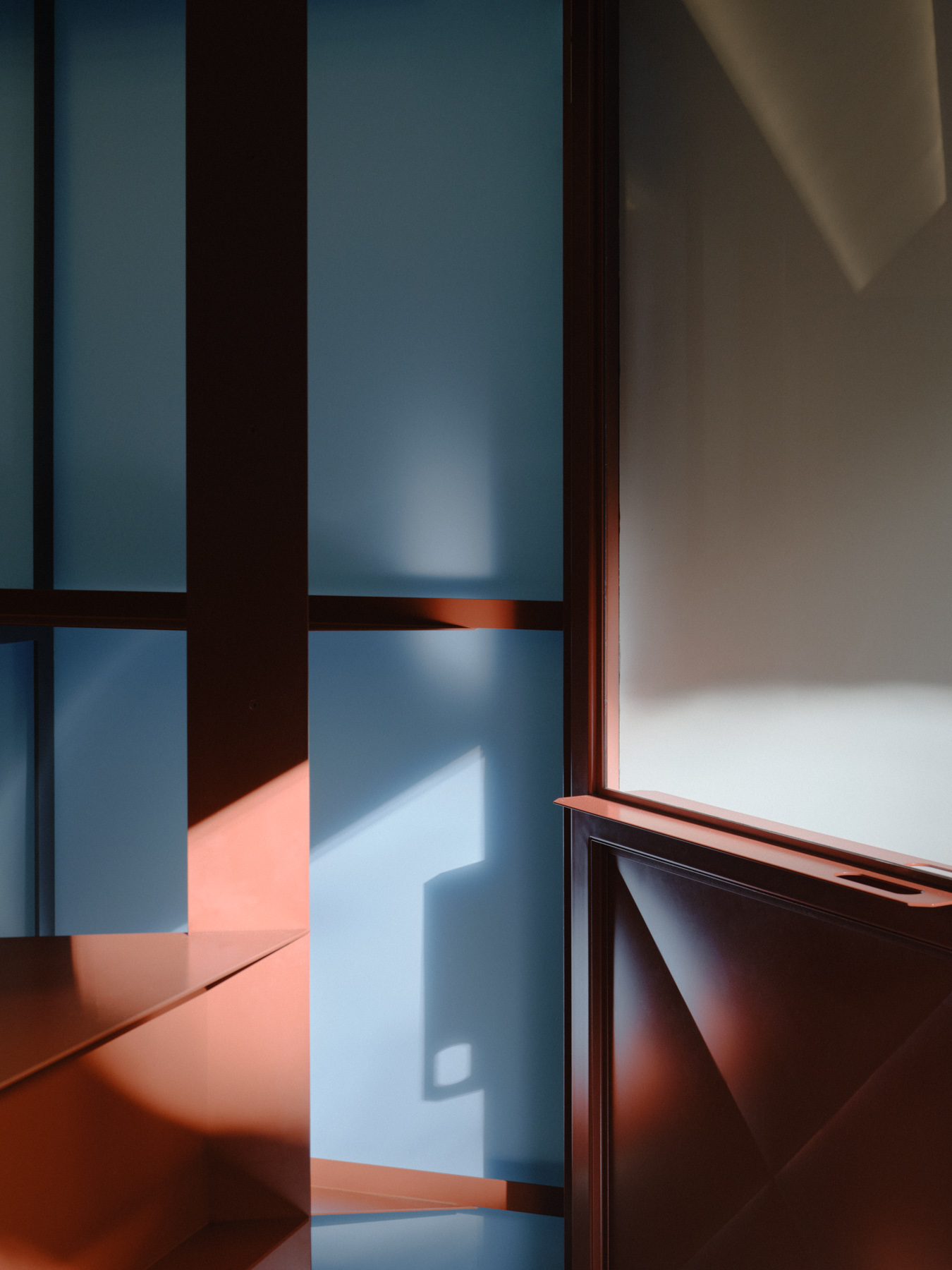 Palace Coffee by KKAP — Photograph captures the storefront threshold of Palace Coffee, framing the interior through a dark timber-framed glazing system.