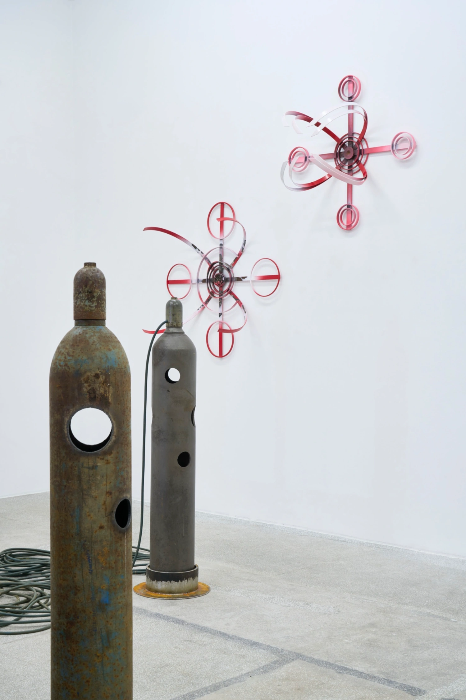Swarm / Rój by Zuza Golinska at Piktogram — Golinska's installation anchors itself in material contrast: weathered steel cylinders with patinated surfaces and perforated apertures sit grounded on...