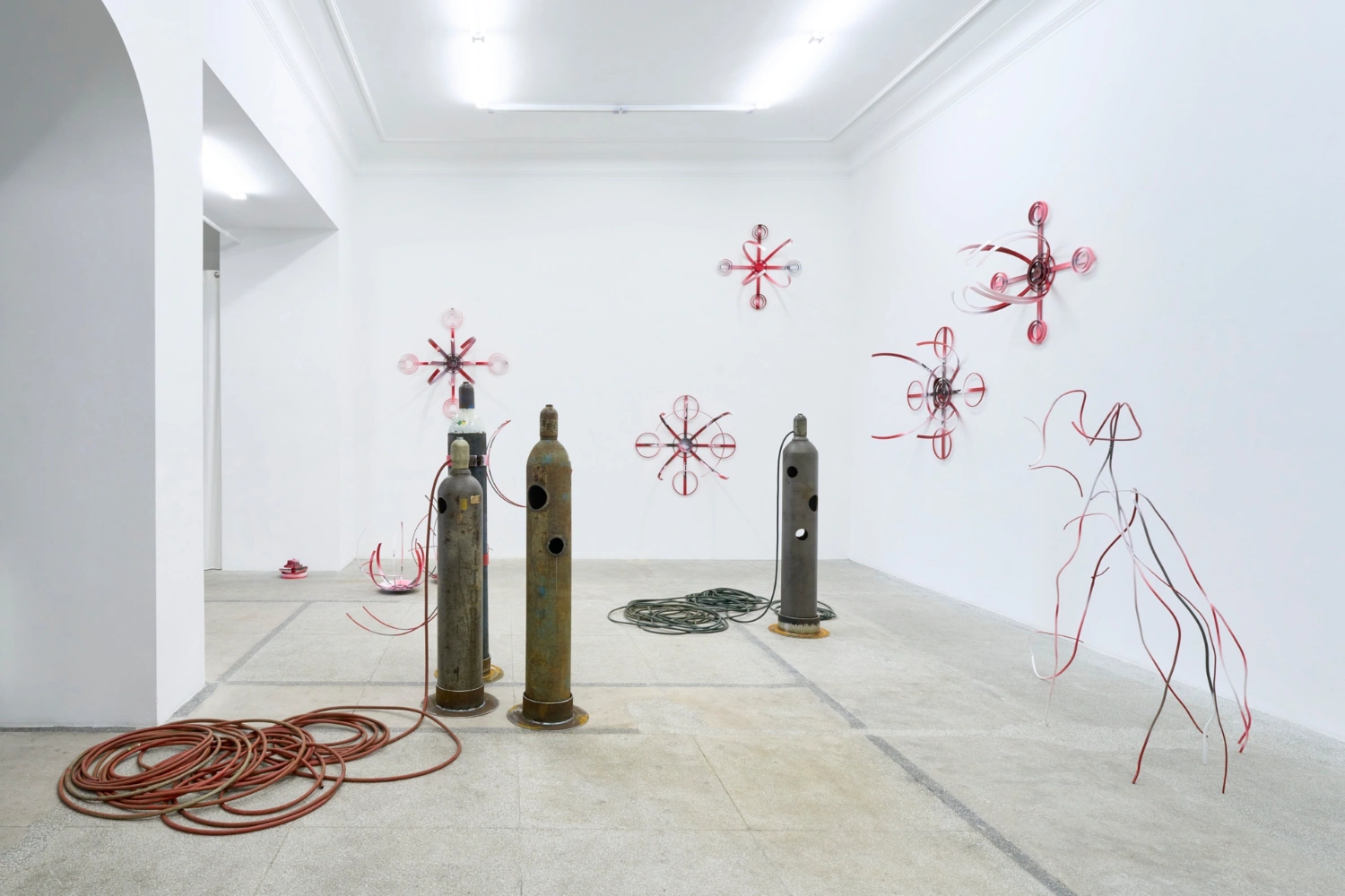 Swarm / Rój by Zuza Golinska at Piktogram — Zuza Golinska's installation stages a dialogue between grounded industrial forms and suspended geometric constructs.