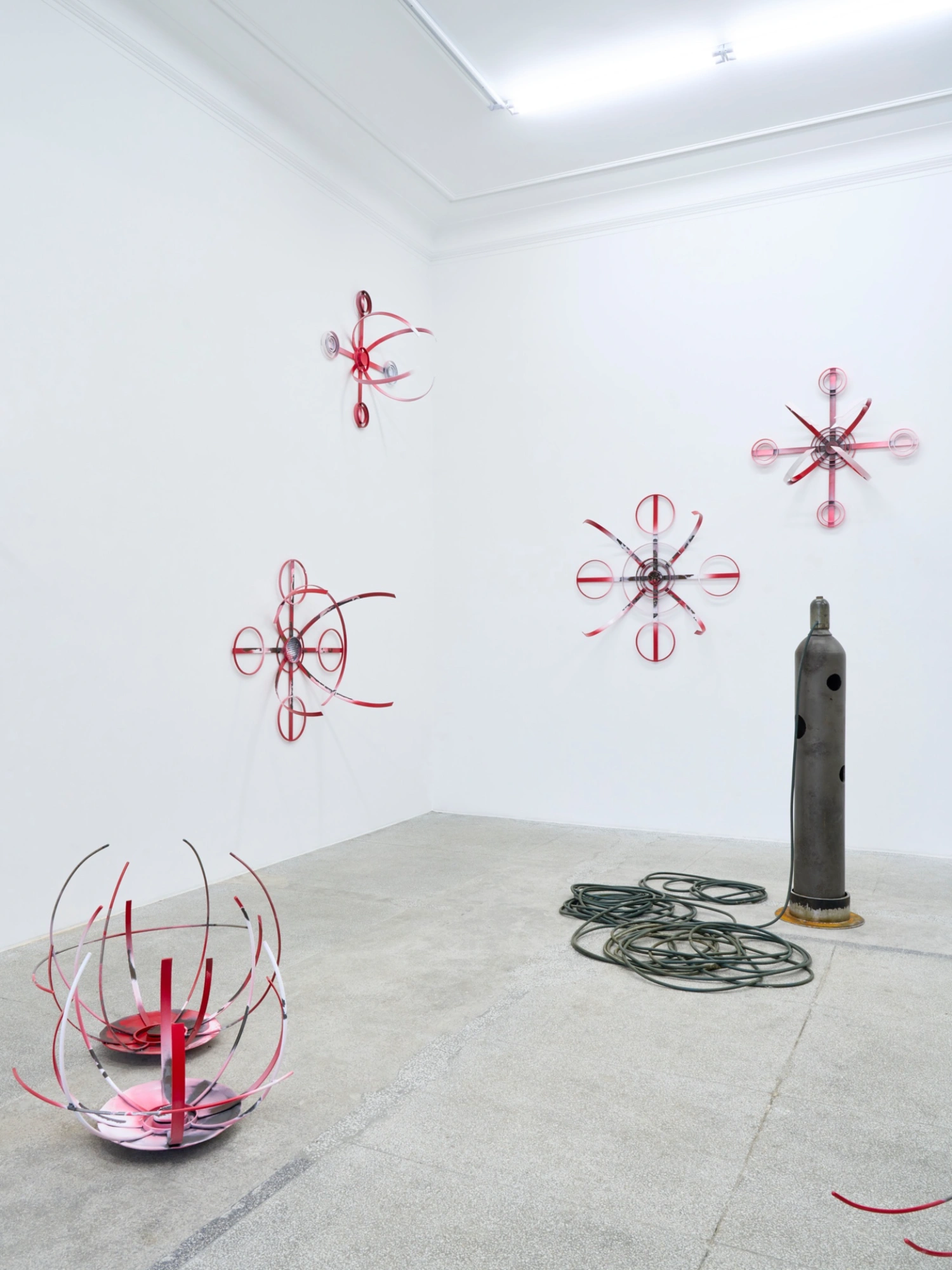 Swarm / Rój by Zuza Golinska at Piktogram — Golinska's installation stages a confrontation between grounded industrial form and suspended geometric abstraction.