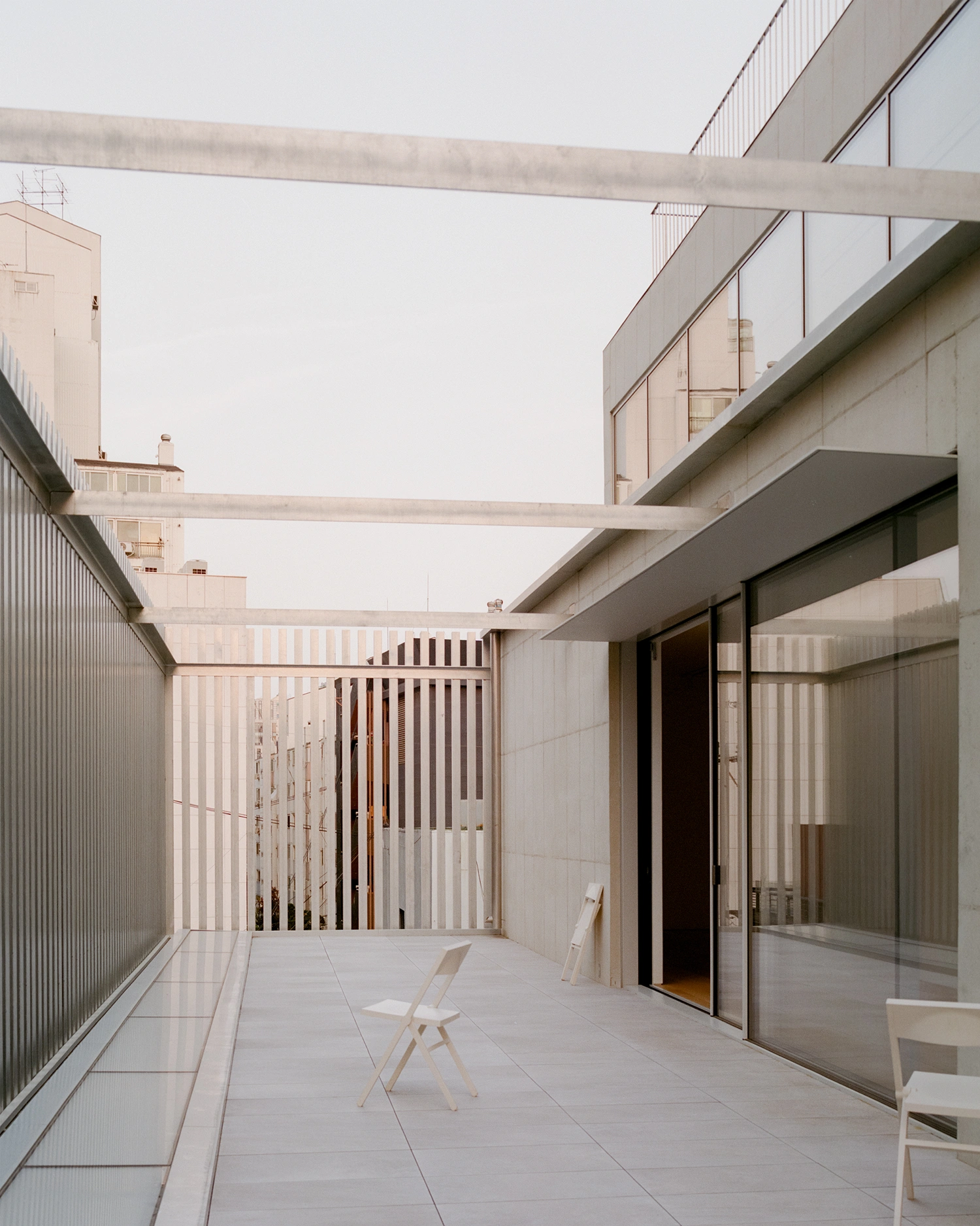 K-Auction Exhibition Hall Sinsa by min_workshop + 3ab — A monolithic concrete terrace anchored by raw ceiling planes and bronze-framed glazing.
