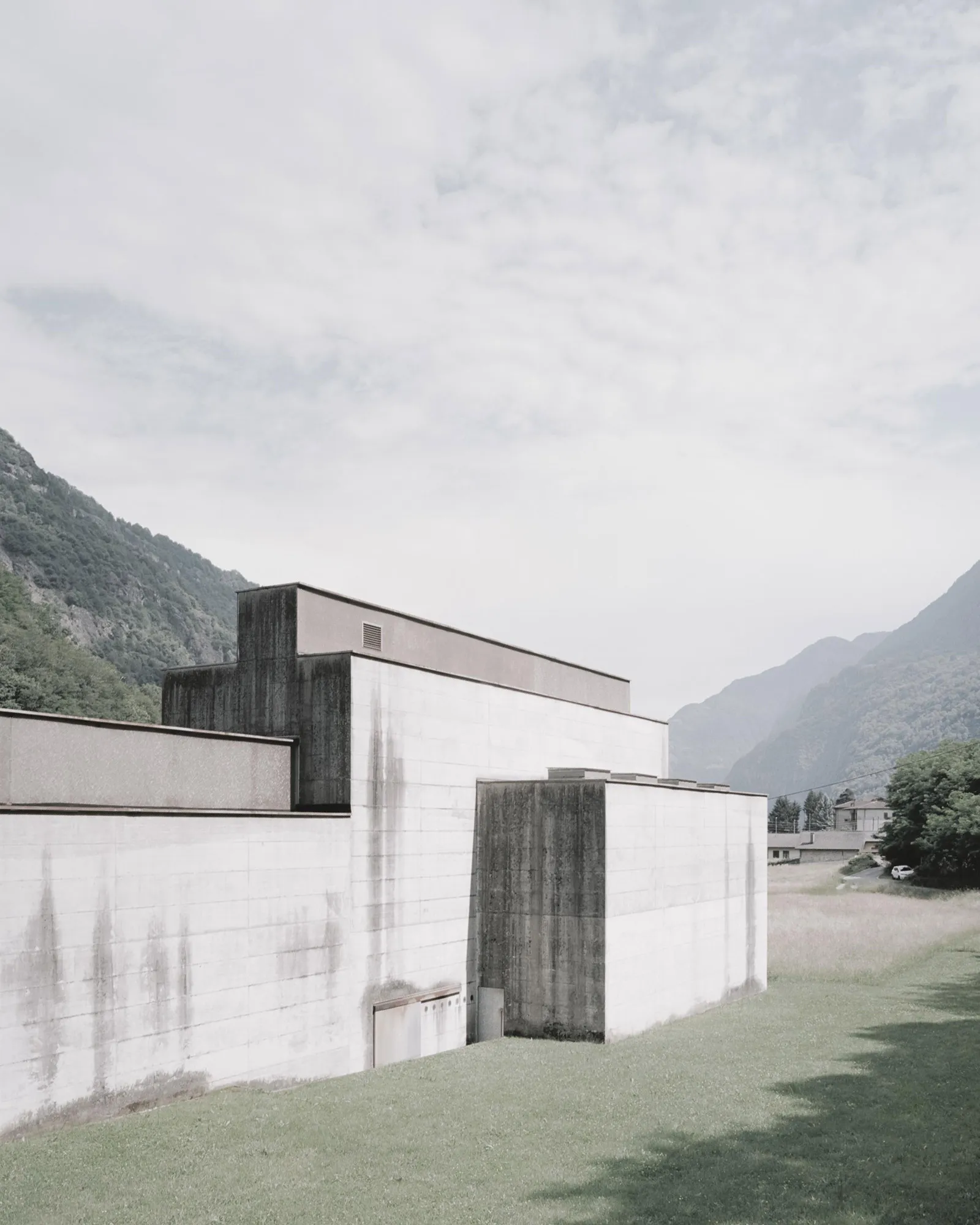 La Congiunta Museum by Peter Märkli — Exterior view of La Congiunta Museum revealing the geometric composition of board-formed concrete volumes set within an Alpine valley landscape.
