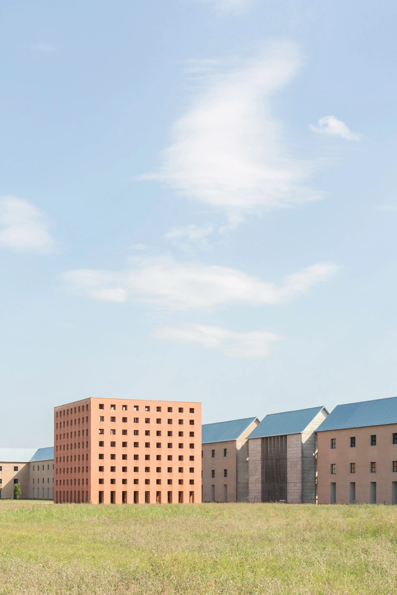 San Cataldo Cemetery by Aldo Rossi — Rossi's San Cataldo Cemetery presents a monolithic terracotta-brick volume punctuated by a regular grid of square voids spanning the entire facade.