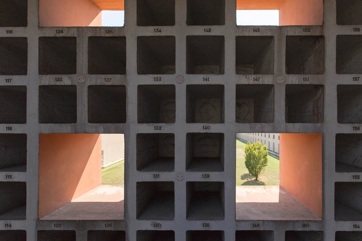 San Cataldo Cemetery by Aldo Rossi — Symmetrical frontality captures the San Cataldo Cemetery's defining formal system: a grid of square apertures pierced through terracotta brick and concrete...