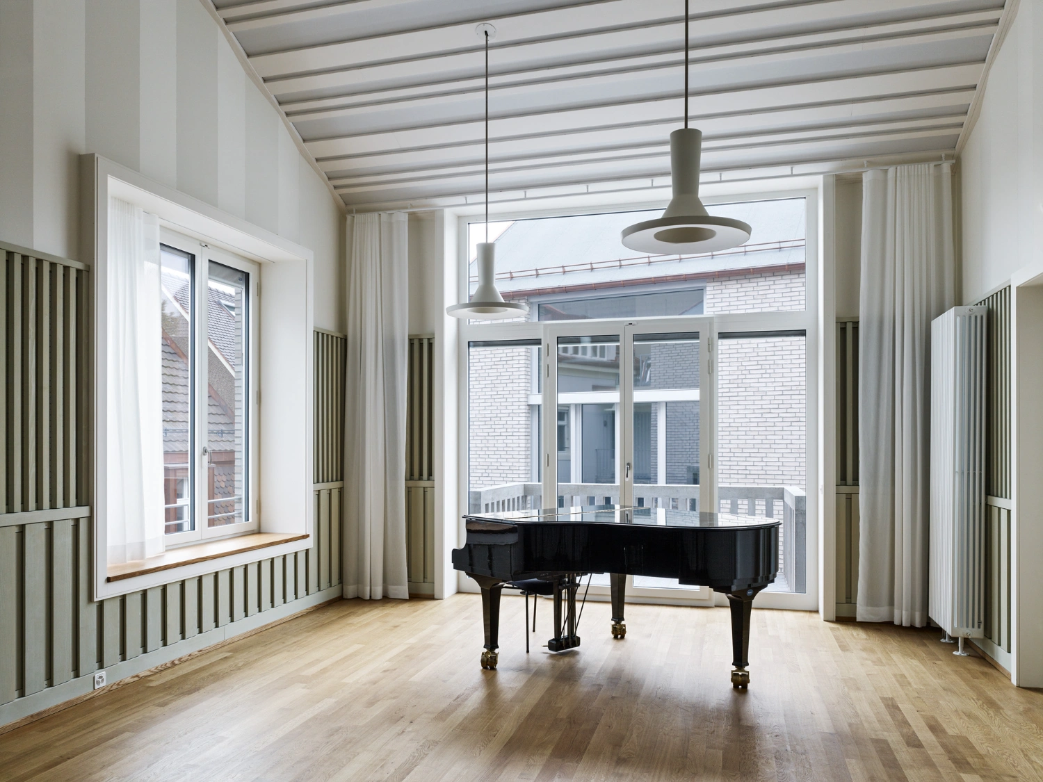 Jazz Campus by Buol & Zünd — A music performance space anchored by a black grand piano positioned centrally on light timber flooring.