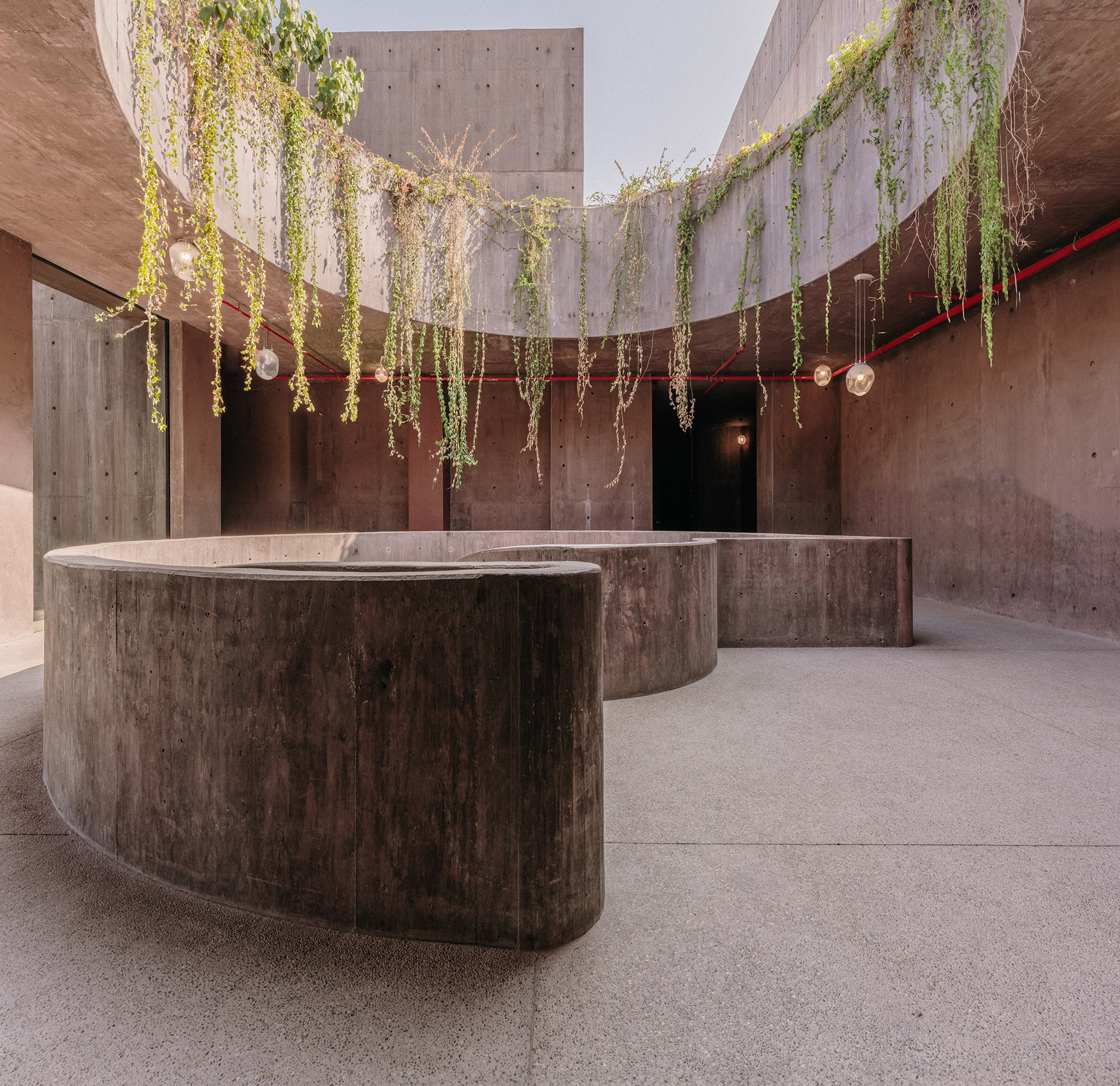 Sea of Cortez Research Center by Tatiana Bilbao — A sunken courtyard anchored by two monolithic concrete circular bench structures, their board-formed surfaces darkened by weathering and age.