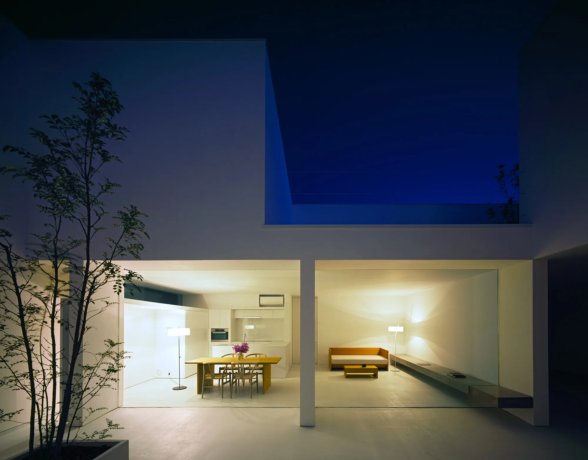 White Cave House by Takuro Yamamoto — The White Cave House courtyard functions as an illuminated spatial threshold at dusk.