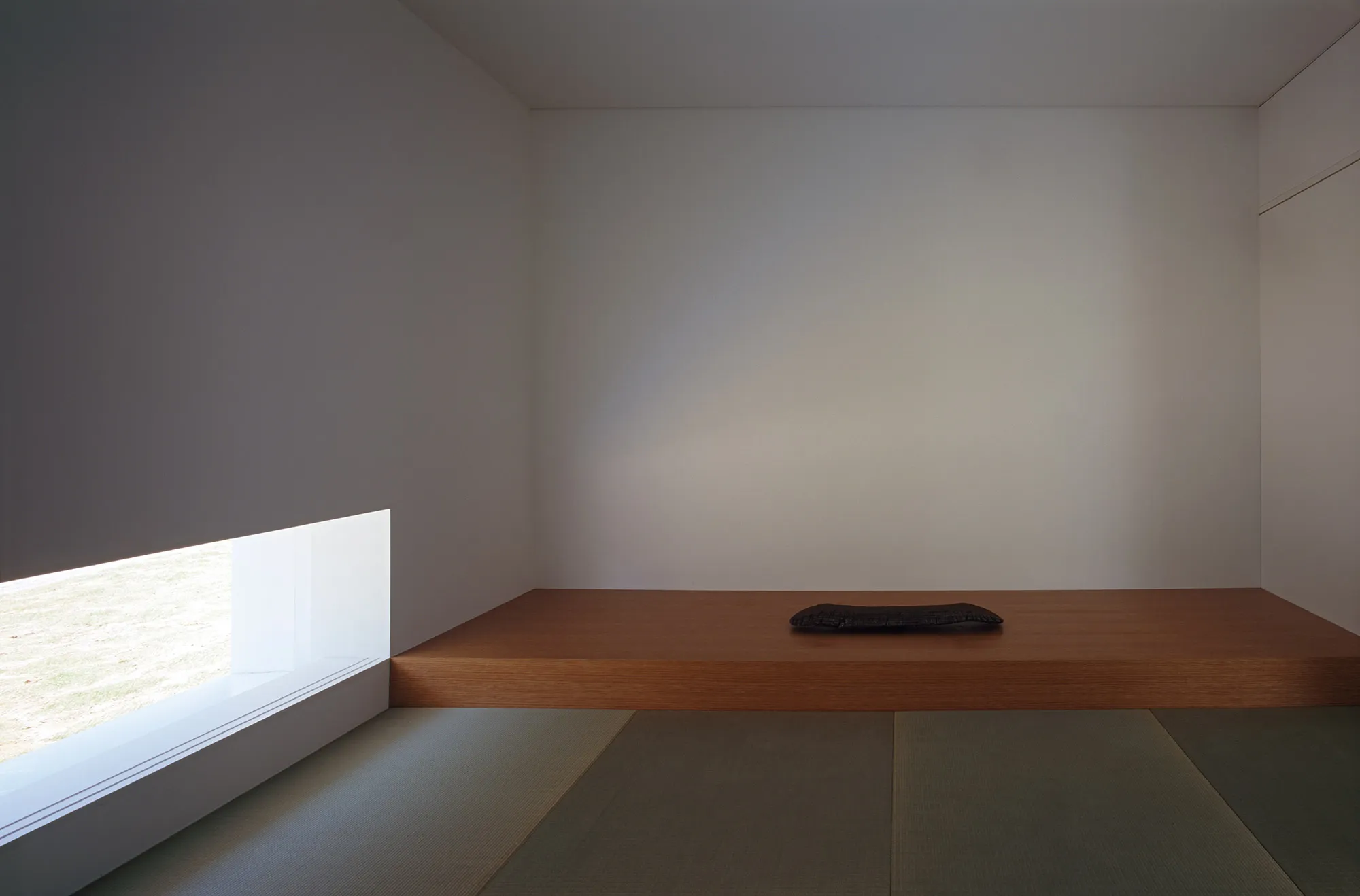 White Cave House by Takuro Yamamoto — Interior view of the White Cave House's recessed void, demonstrating the project's spatial strategy of casting the courtyard as a functional passage rather...