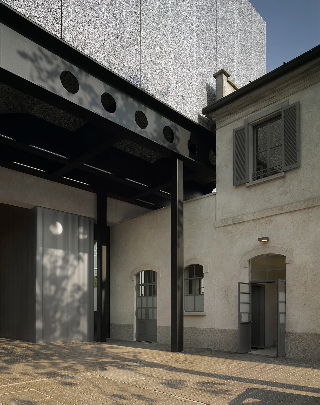 Fondazione Prada by OMA — A courtyard threshold framed by architectural heterogeneity.