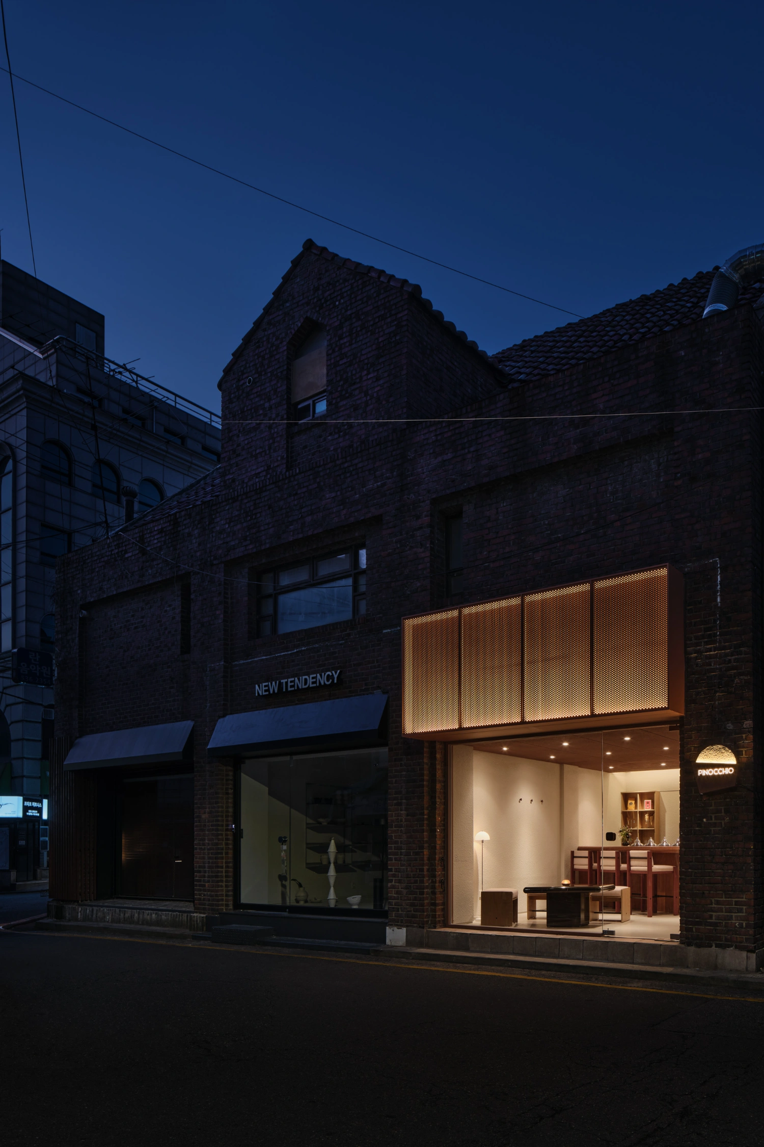 PINOCCHIO Gelato + Coffee Shop by WARP AND WOOF — A storefront at dusk reveals the contrast between Seoul's preserved industrial heritage and contemporary insertion.