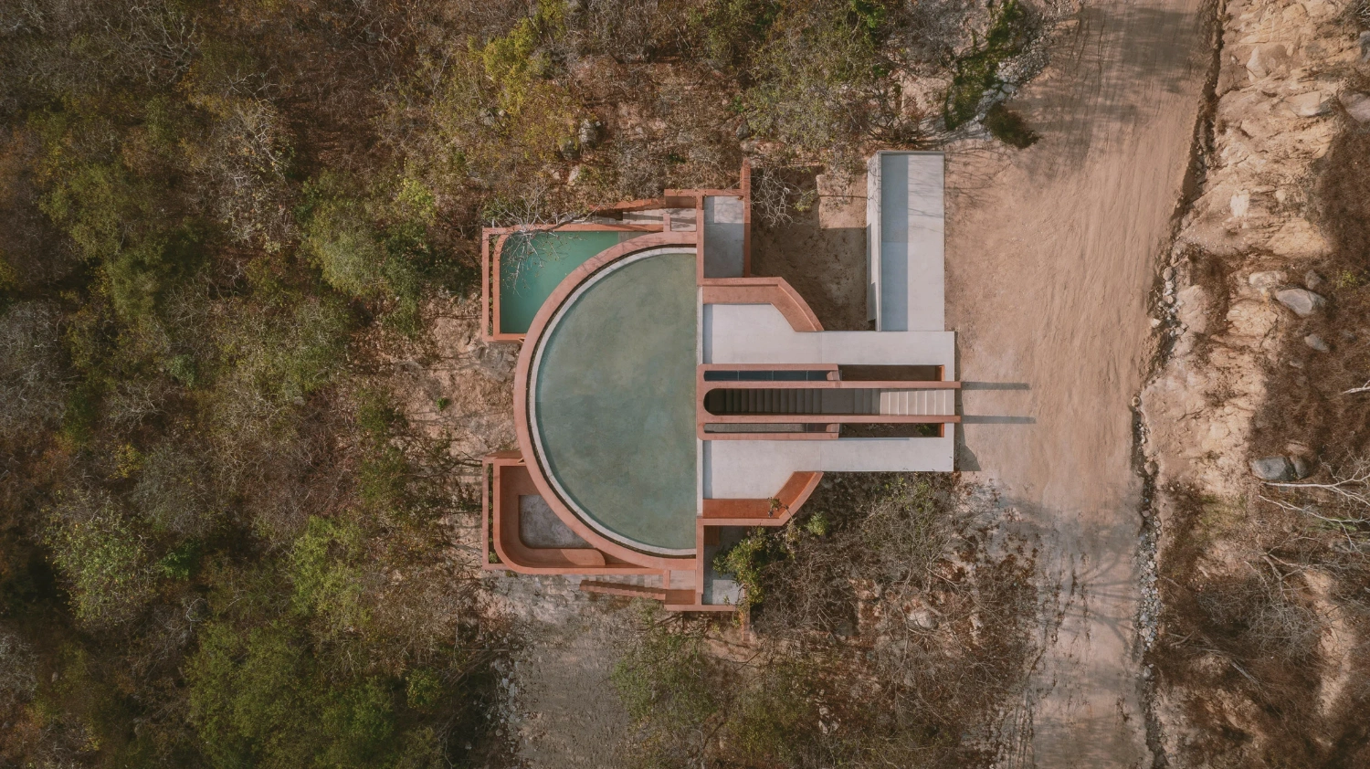 Casa Tobi by Espacio 18 Arquitectura — Aerial view of Casa Tobi reveals its volumetric composition descending into the Oaxacan landscape.