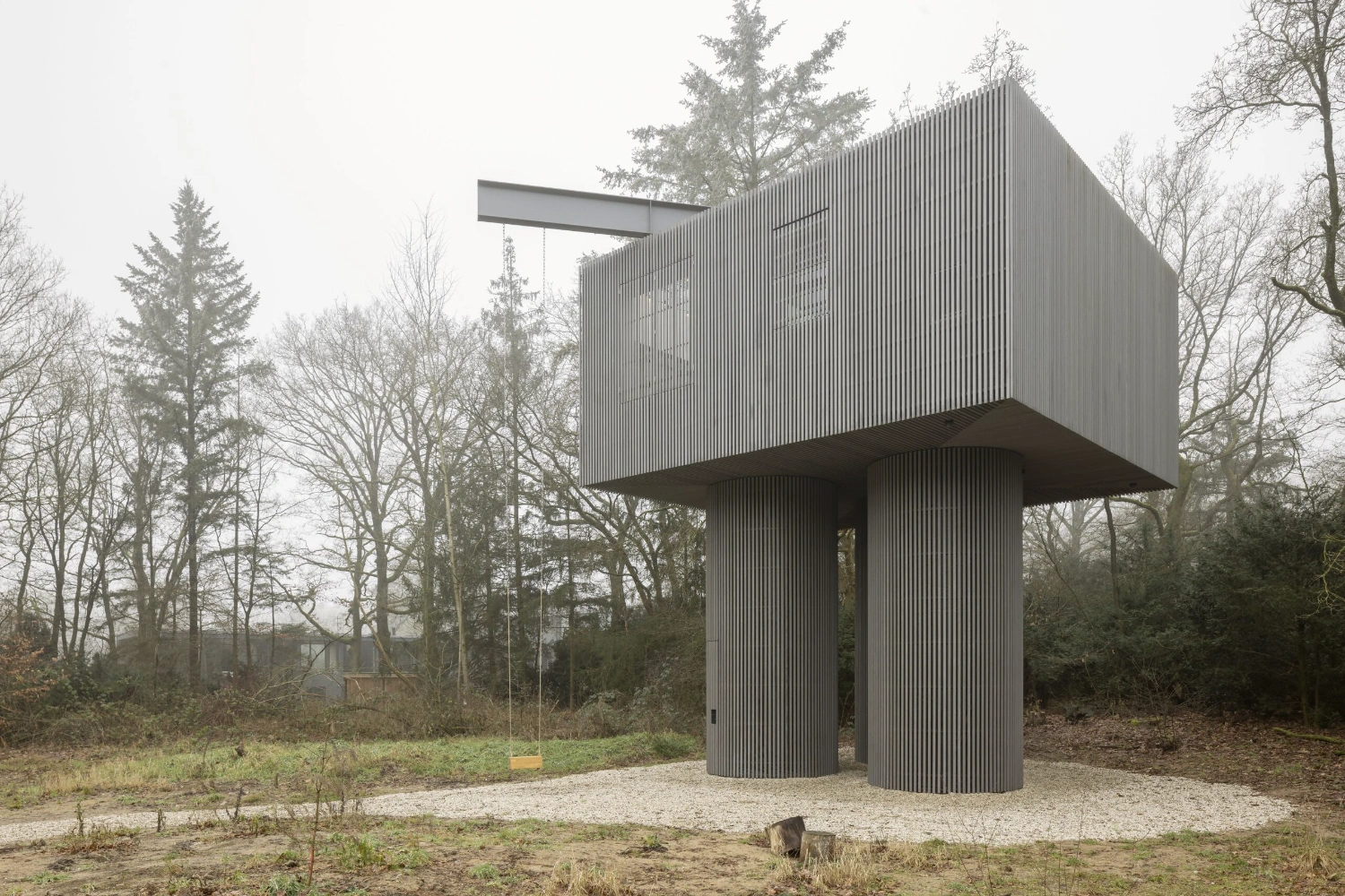 Dolmen by Space Encounters — A corrugated metal tower rises from a woodland clearing in Arnhem, its facade clad entirely in vertical ribbed steel.