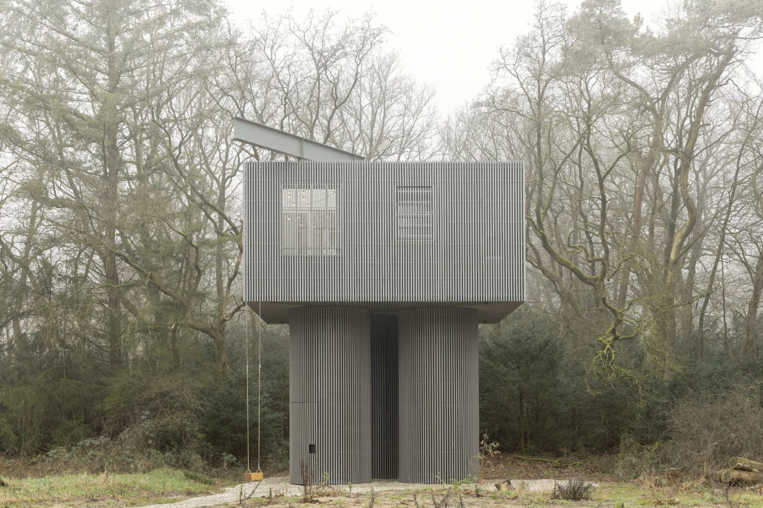 Dolmen by Space Encounters — Photographed from ground level in winter woodland, this elevated structure presents a geometric counterpoint to the skeletal forest canopy.