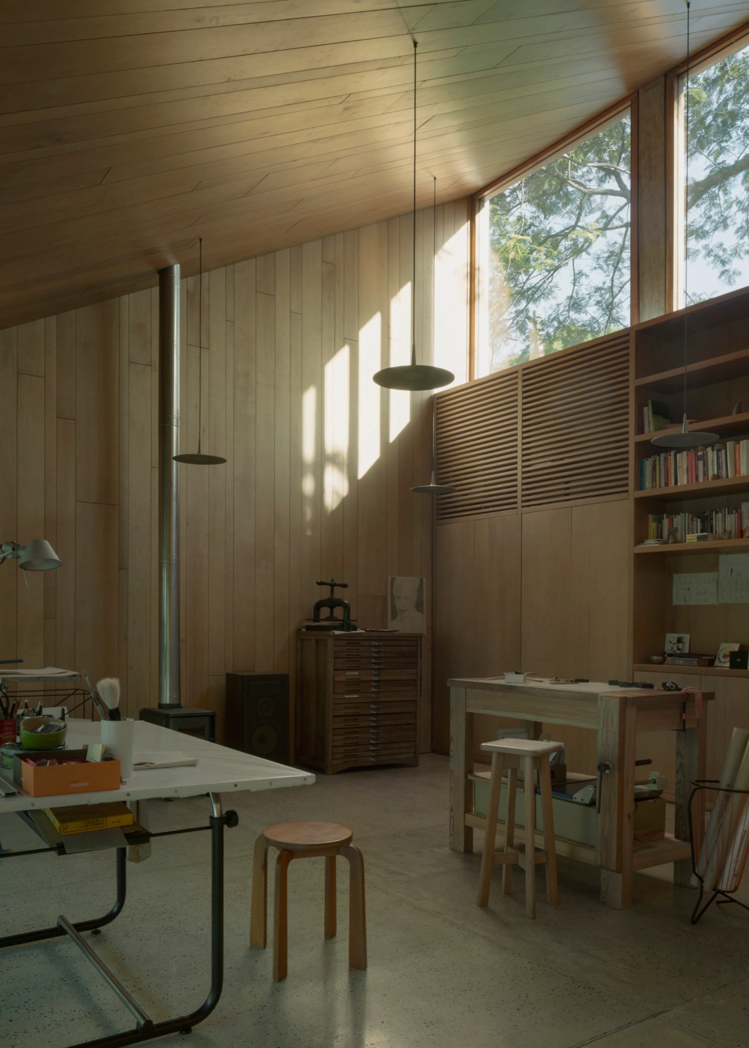 Atelier Workshop by Agustín Berzero — Interior view of the workshop studio flooded with golden-hour light through large glazed southern elevation.