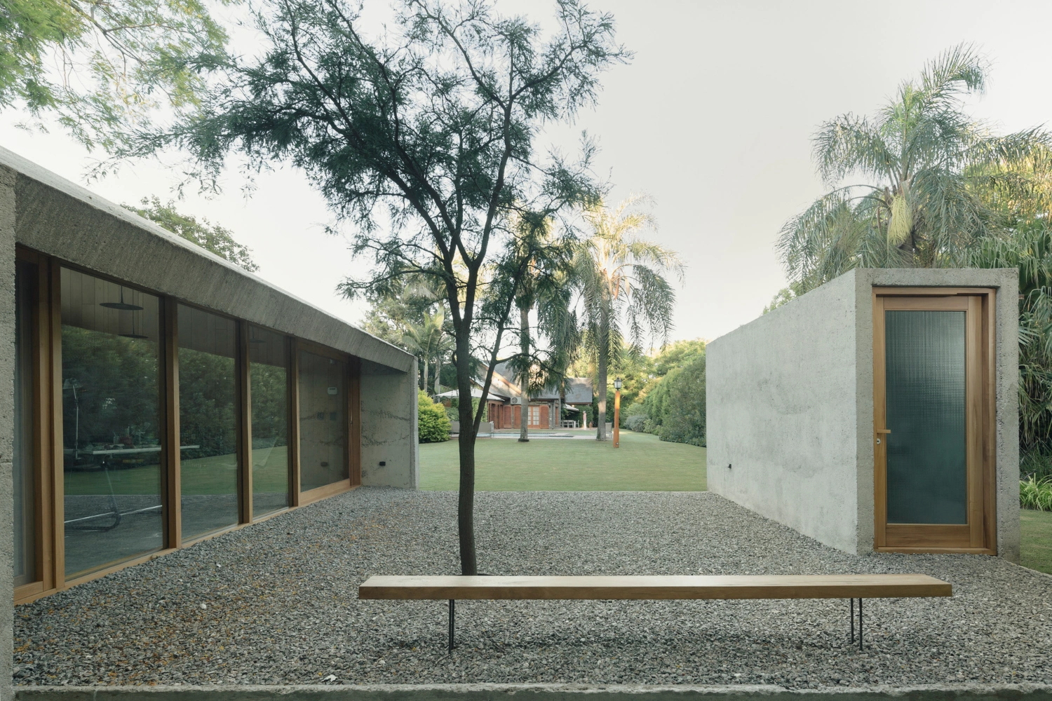 Atelier Workshop by Agustín Berzero — Agustín Berzero's workshop presents itself as two rectilinear concrete volumes framing a gravel courtyard.