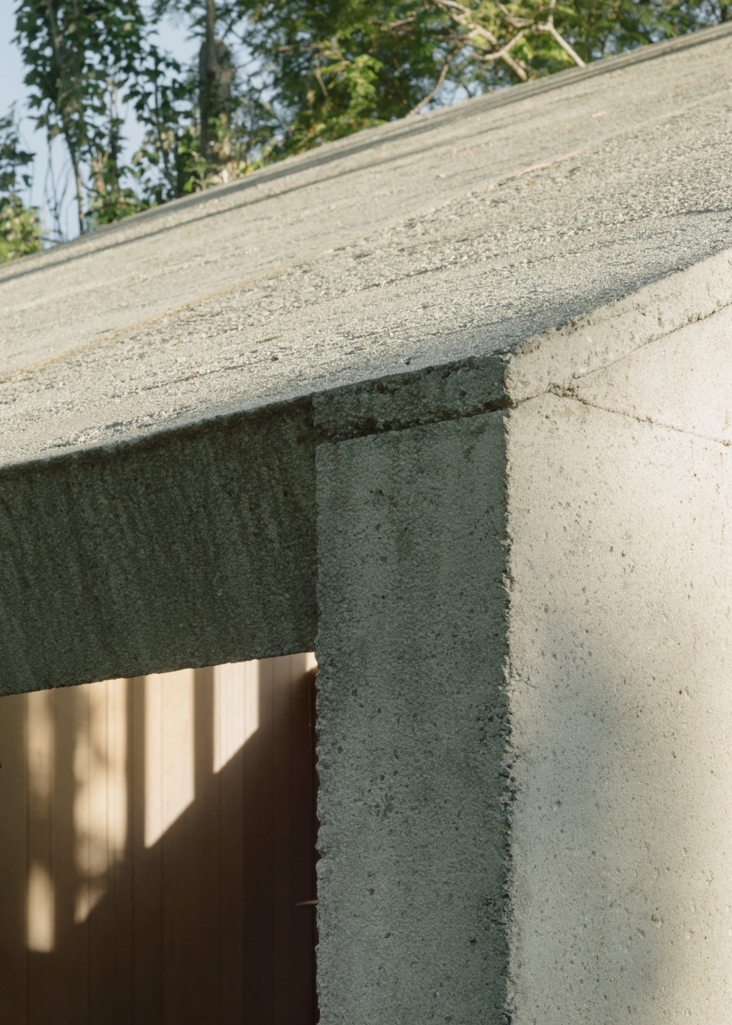 Atelier Workshop by Agustín Berzero — Close-up detail of the workshop's concrete construction at the corner junction, revealing the monolithic-cast technique and material hierarchy.