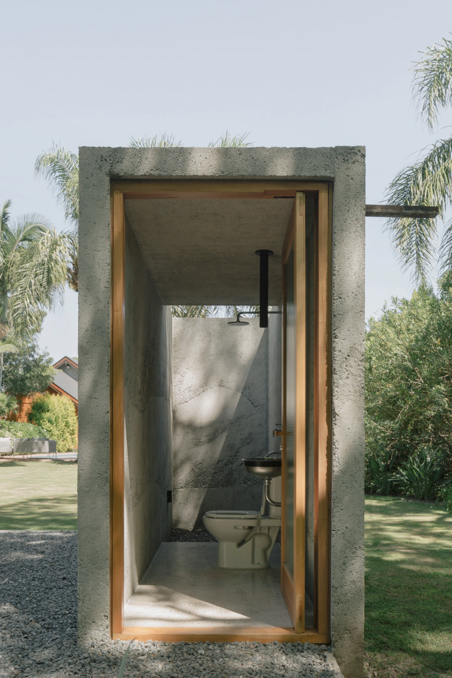 Atelier Workshop by Agustín Berzero — A monolithic concrete pavilion containing a minimal bathroom, photographed from the threshold.