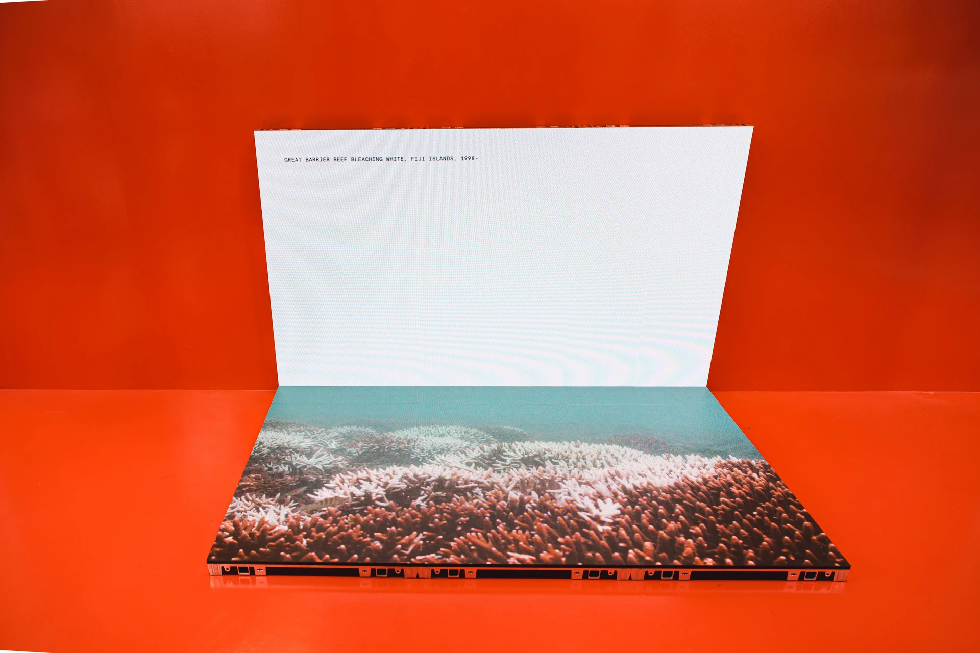032c Gallery in Seoul by Gonzales Haase AAS — A product presentation featuring a coffee table book or portfolio case documenting the Great Barrier Reef bleaching event in Fiji from 1998.
