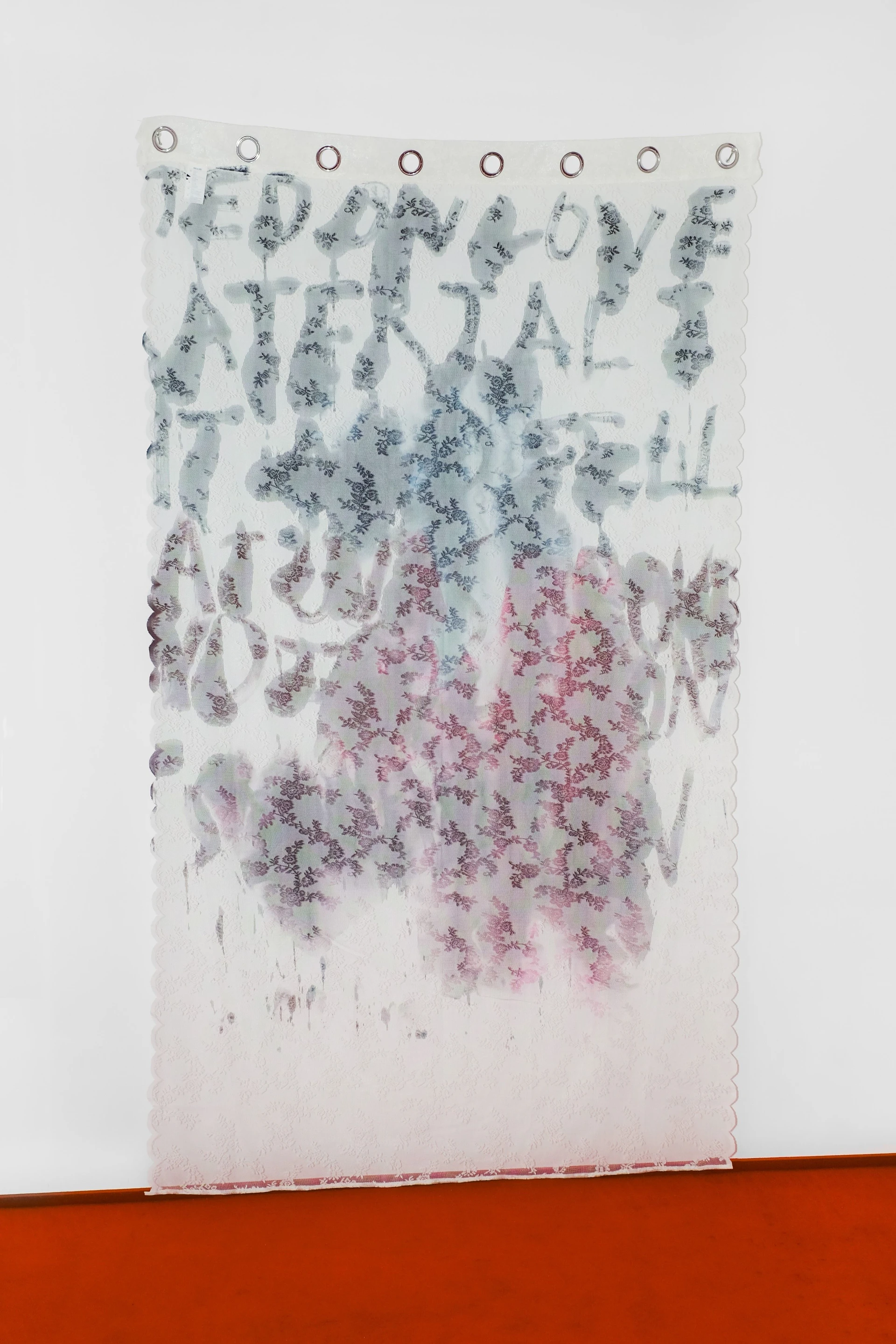 Productive Narcissism at 032c Gallery in Berlin — A translucent fabric panel suspended from eight metal rings displays layered text rendered in botanical prints.
