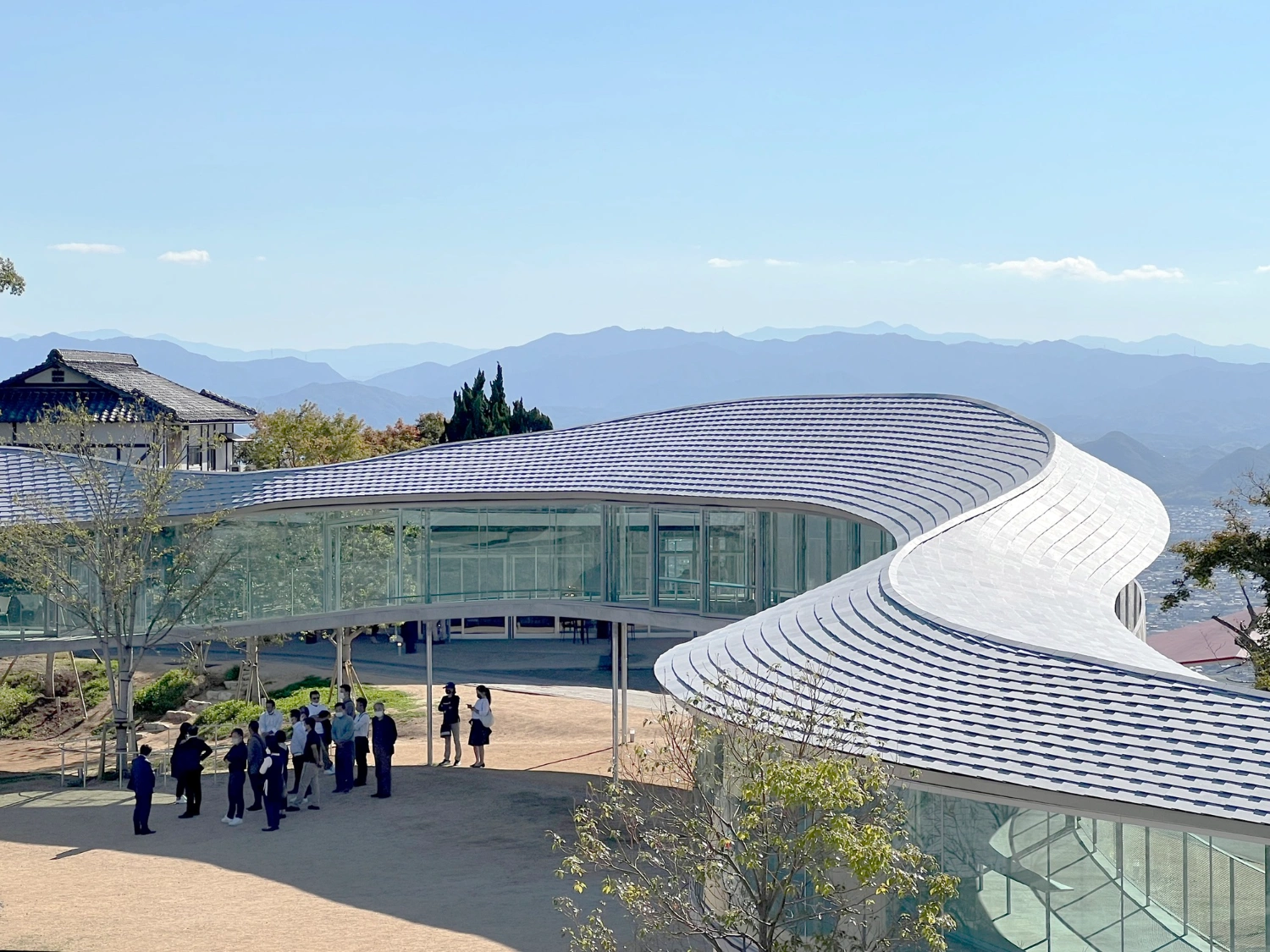 Yashima Mountaintop Park by SUO + Style-A — The Yashima Mountaintop Park's continuous white concrete ribbon curves through the landscape, its rippled roof surface catching directional light.