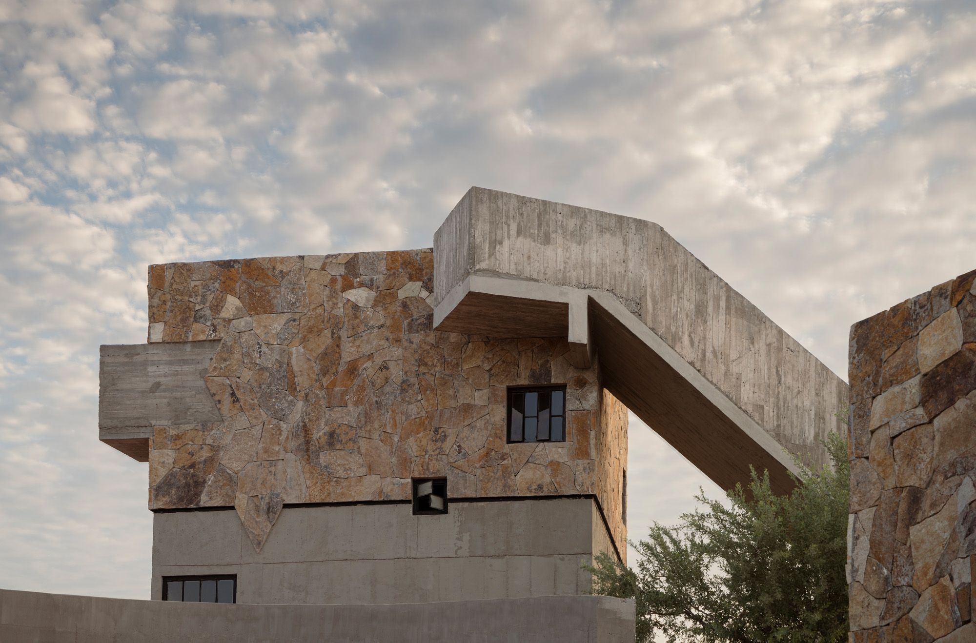 Casa La Paz by Ludwig Godefroy Architecture — Casa La Paz presents a stacked volumetric composition photographed from the sunken courtyard threshold.