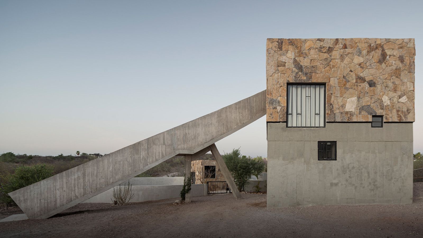 Casa La Paz by Ludwig Godefroy Architecture — Casa La Paz presents a dramatic volumetric composition where a cantilevered concrete slab extends horizontally over a lower rectilinear volume.