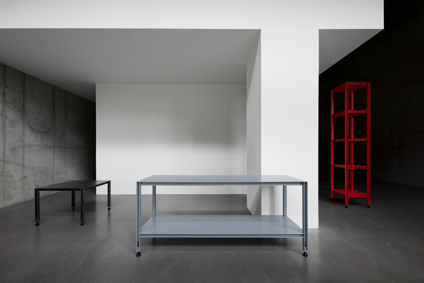 Full Metal by Matteo Bauer-Bornemann — A steel-framed table with powder-coated blue-grey finish occupies the center of a minimalist interior.