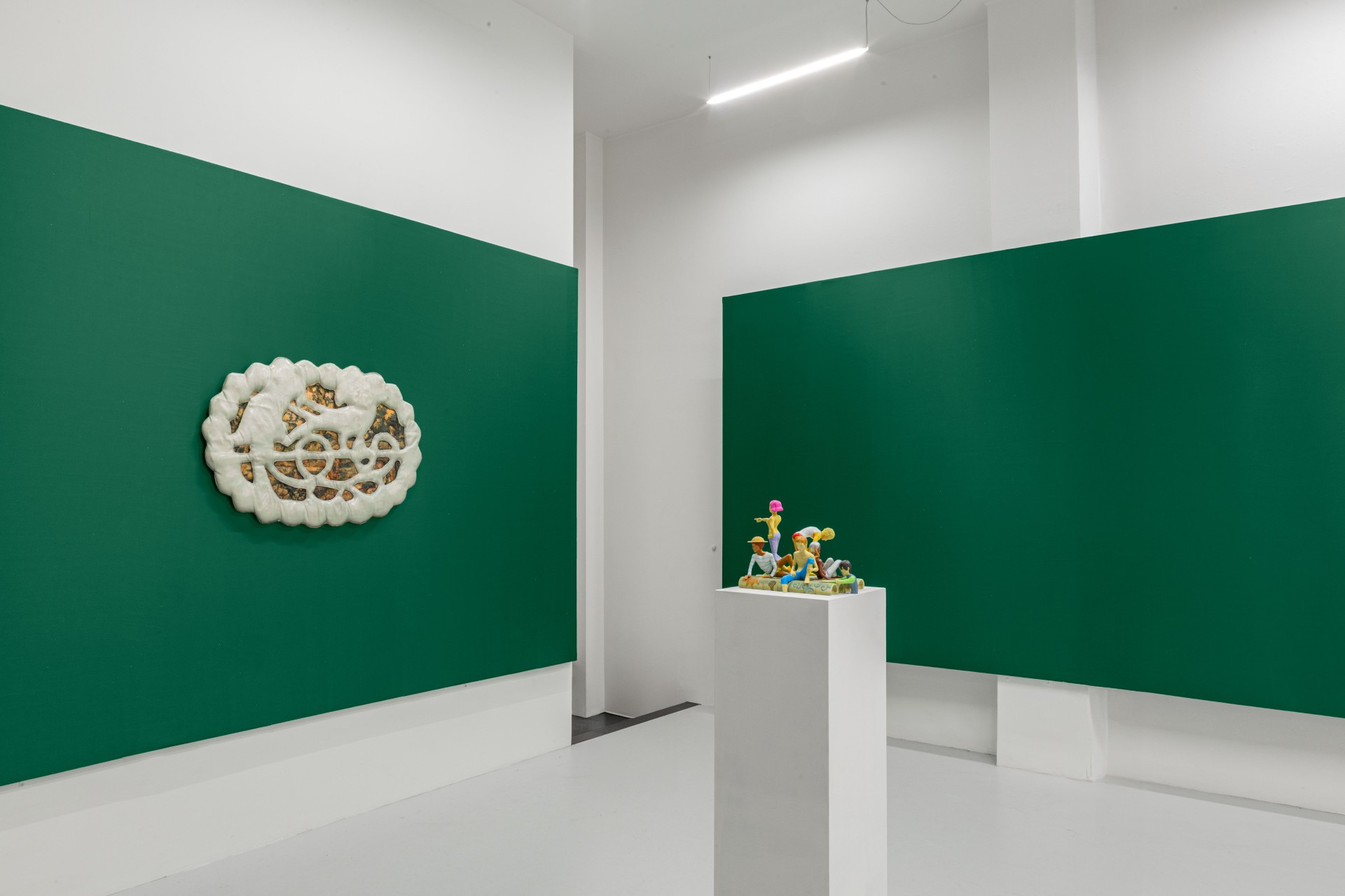 Till the cows come home at banquet — A gallery interior divided by angled green wall planes that create dynamic spatial apertures.