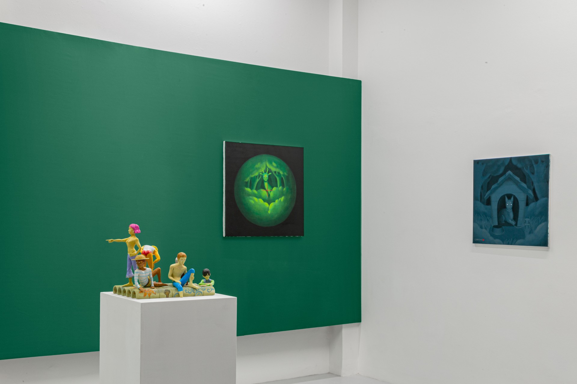 Till the cows come home at banquet — A sculptural installation occupies a white pedestal within an angled green wall structure, featuring colorful figures in yellow, pink, and blue arranged in...