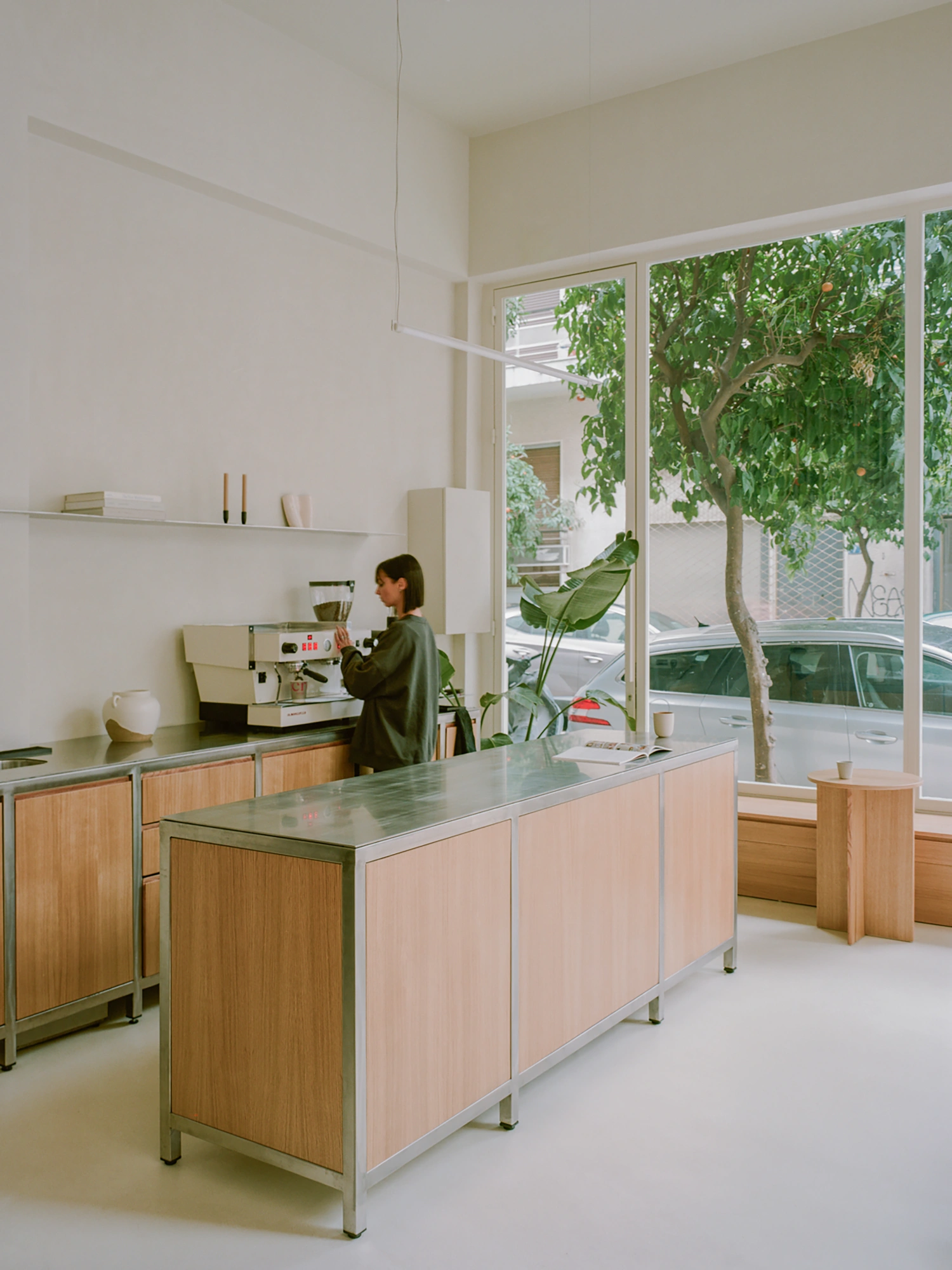 Moden Café by Georgios Apostolopoulos — A ground-floor café interior captures a barista operating an espresso machine at the rear counter.