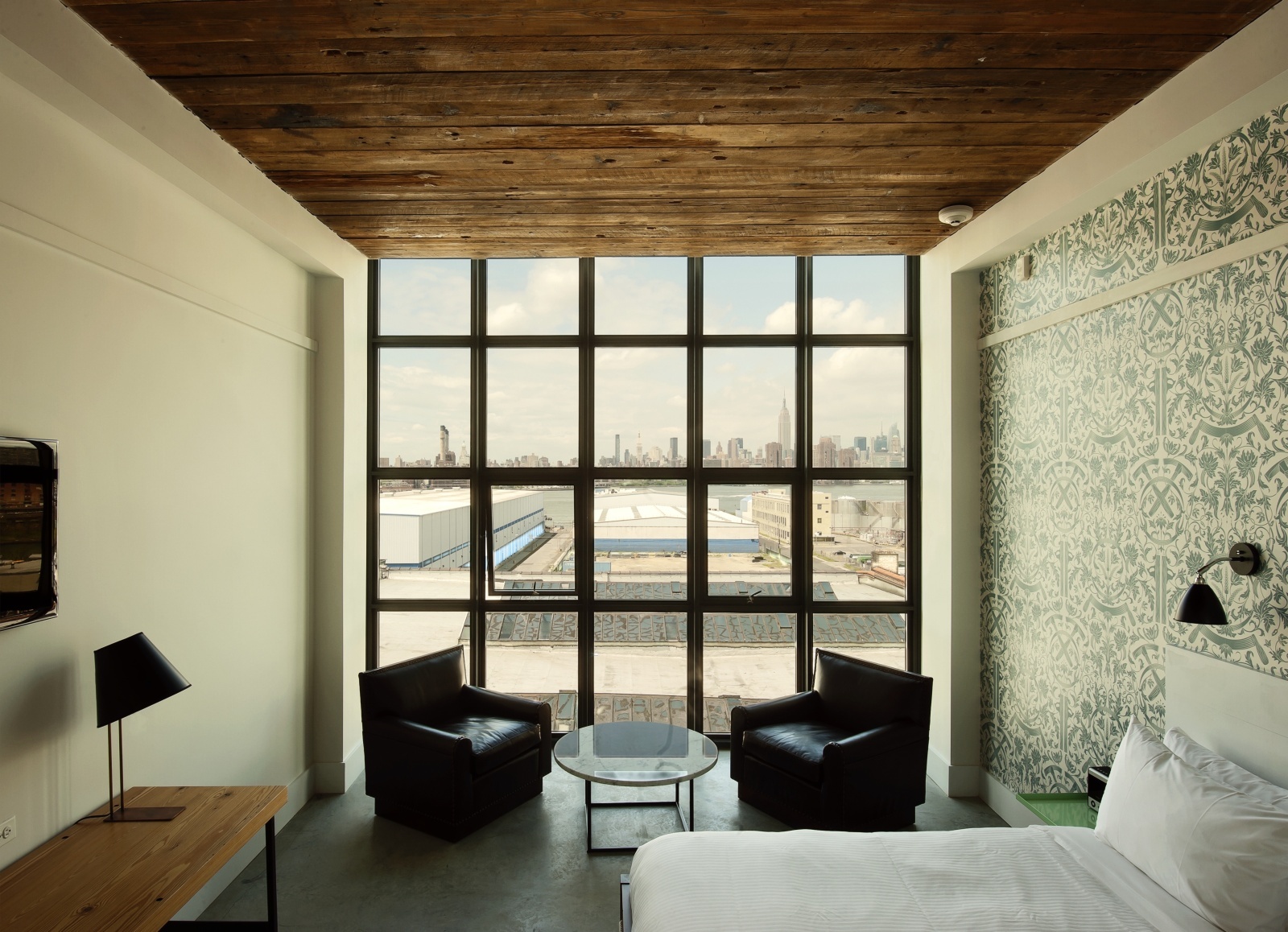 Wythe Hotel New York by Morris Adjmi Architects — A corner hotel bedroom demonstrates the architectural strategy of material contrast defining the Wythe Hotel's identity.