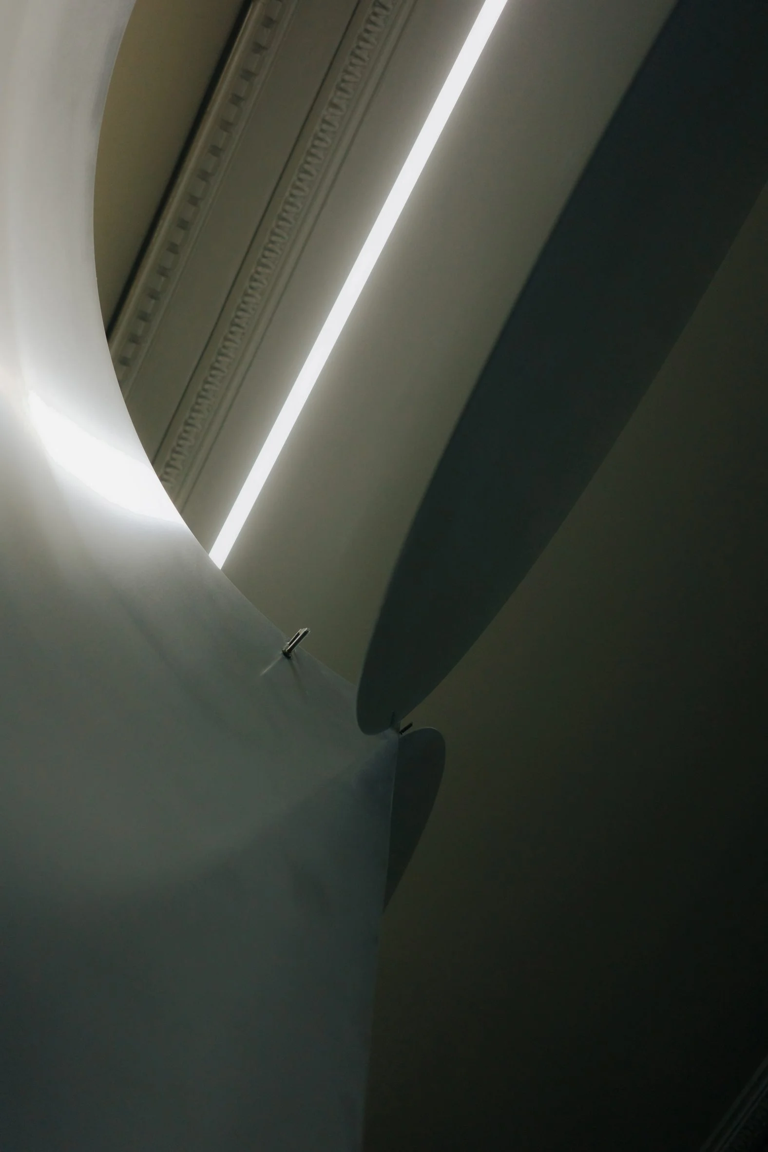 Simple Coffee by Mur Mur Architects — A view down the café's central axis captures the interplay of brushed stainless steel surfaces and linear fluorescent lighting.