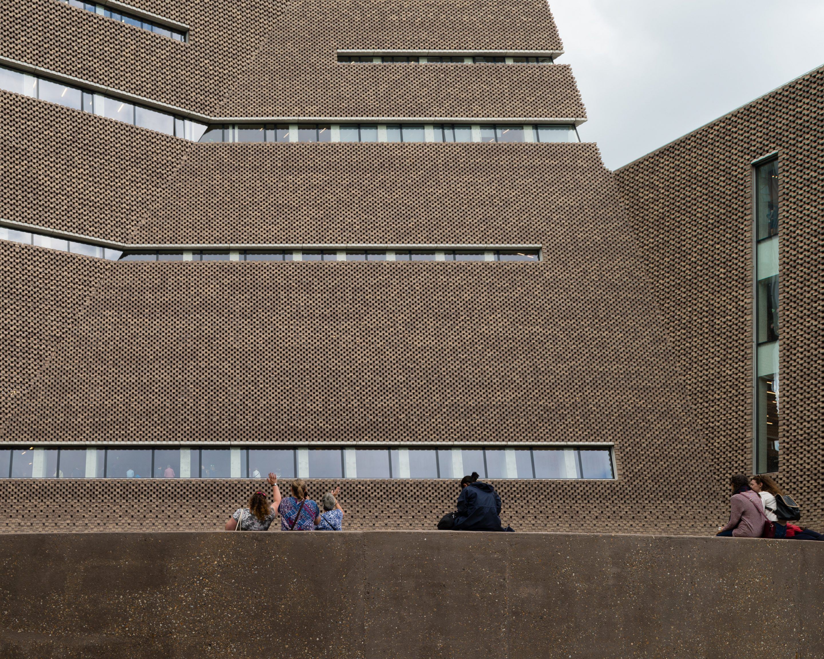 The Tate Modern by Herzog & de Meuron — The Tate Modern's brick facade dominates this view, its tightly woven diagonal pattern creating pronounced surface texture across the expanse.