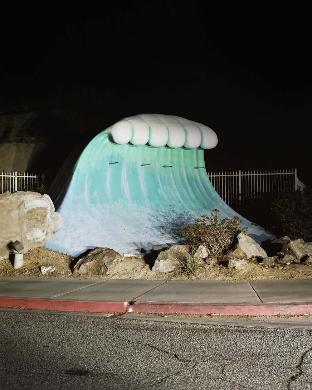 A Poor Sort of Memory by Tracy L Chandler — A sculptural wave form, rendered in white and turquoise pigment, dominates a desert roadside installation.
