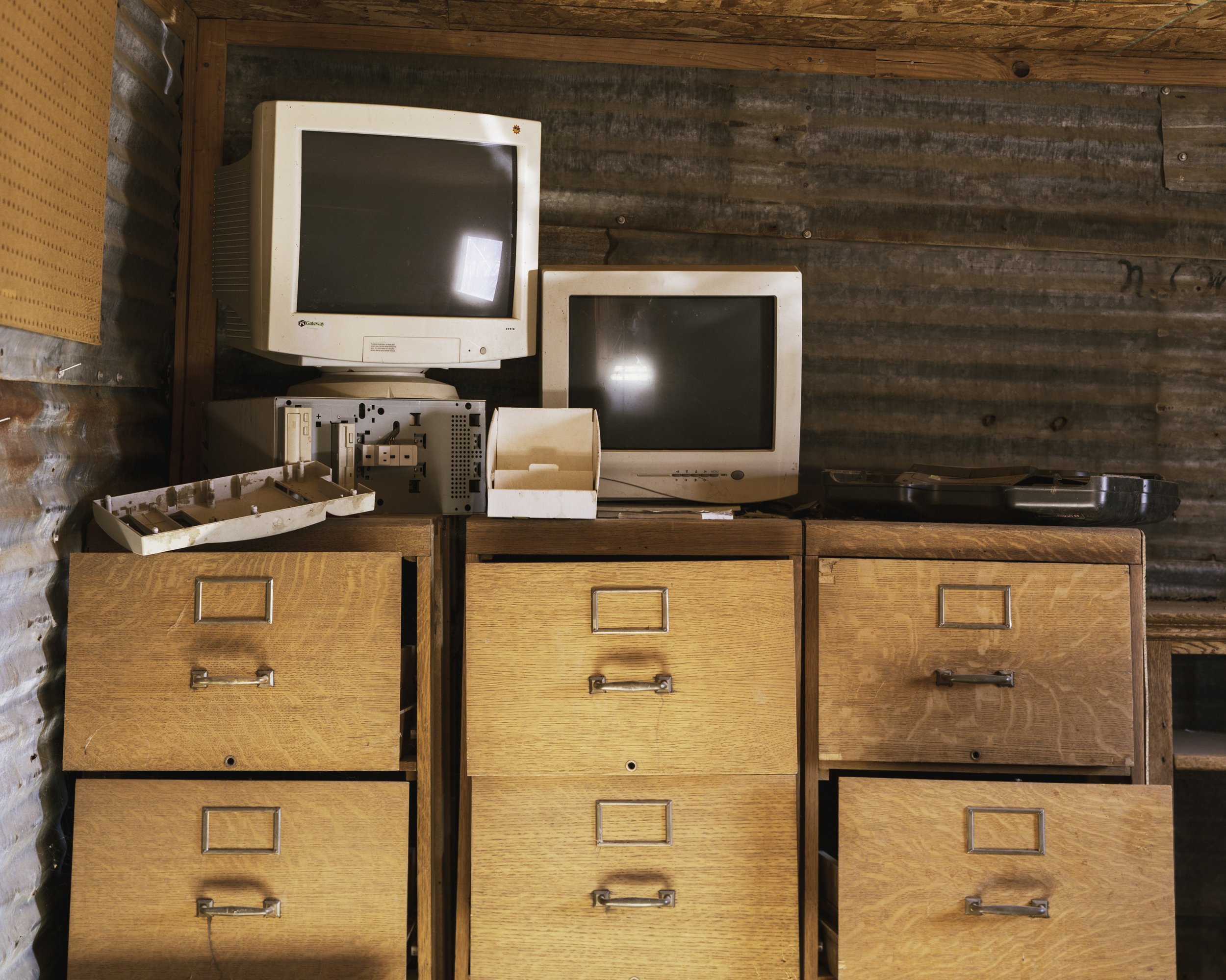 A Poor Sort of Memory by Tracy L Chandler — Photograph of vintage computer equipment and filing cabinets arranged in a storage interior.