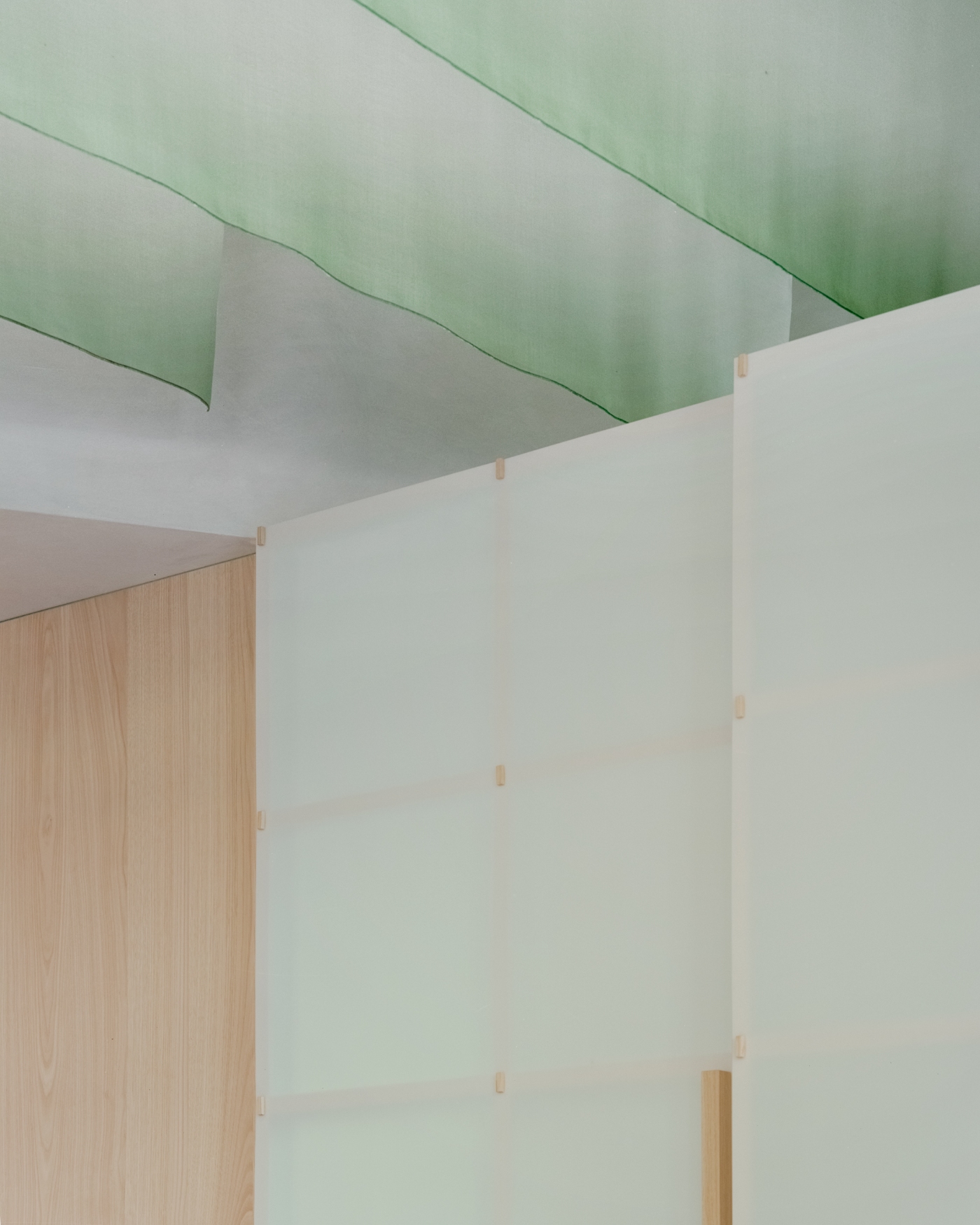 PAN Milano by studio wok — Overhead view of PAN Milano's service counter featuring a green fiberglass grating surface with soft luminosity.