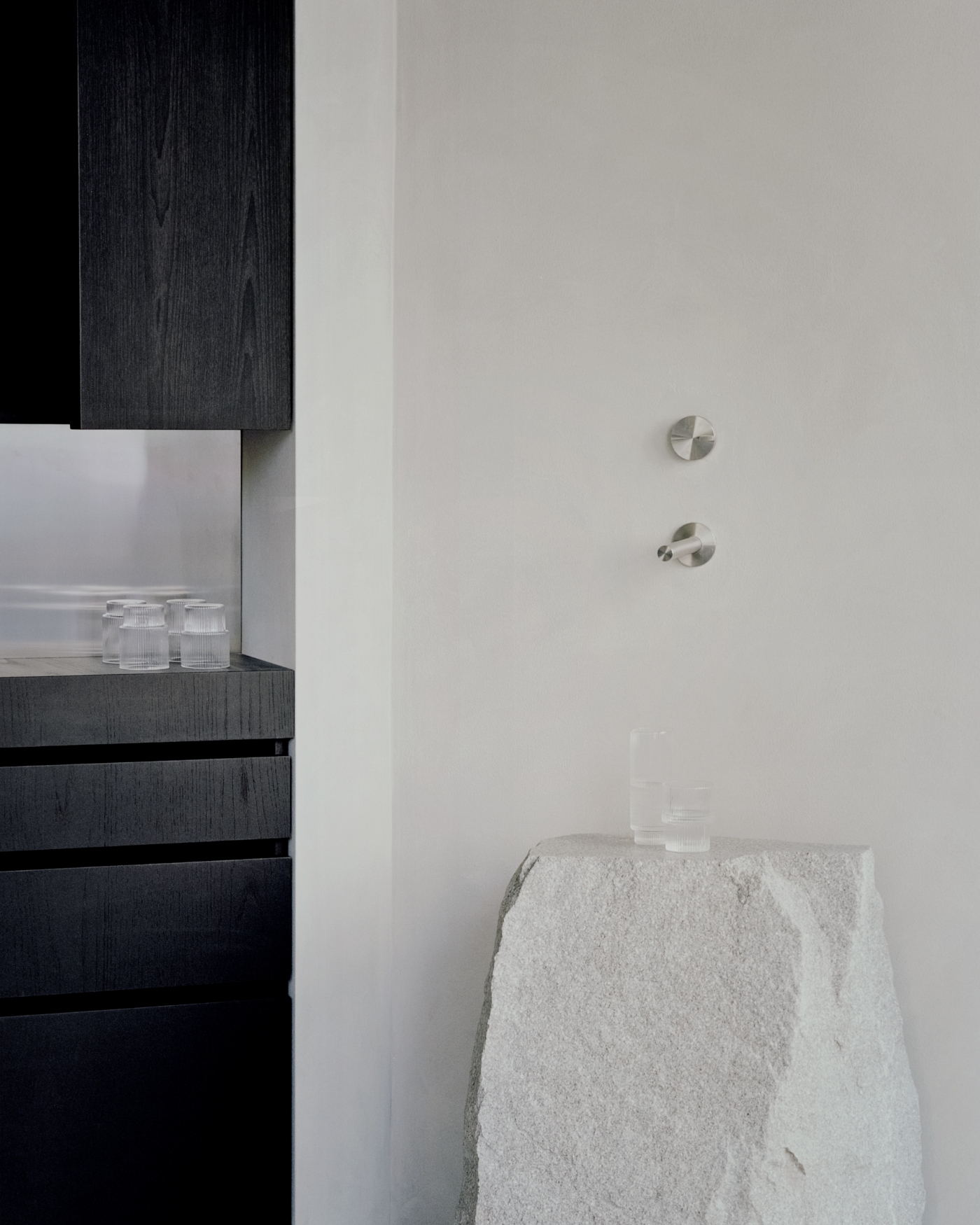 PAN Milano by studio wok — A detail view of PAN Milano's bathroom threshold reveals the material dialogue between black-stained timber cabinetry on the left and a sculptural white...
