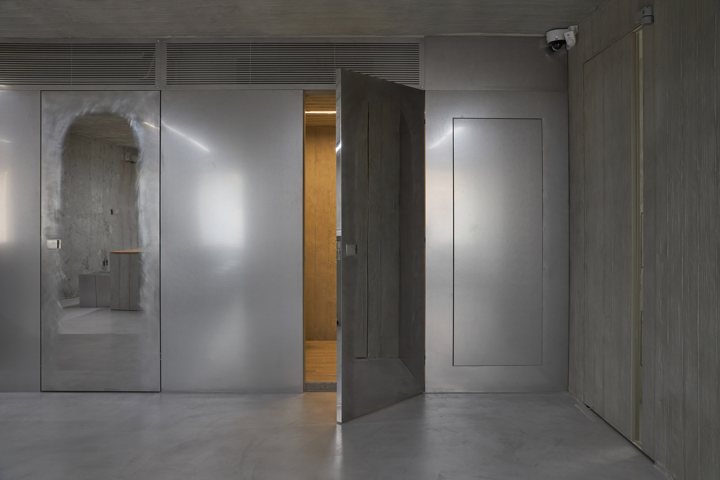 HAHOUSE Cafe by Niceworkshop — The HAHOUSE Cafe entrance presents a deliberate materiality clash across a single threshold.