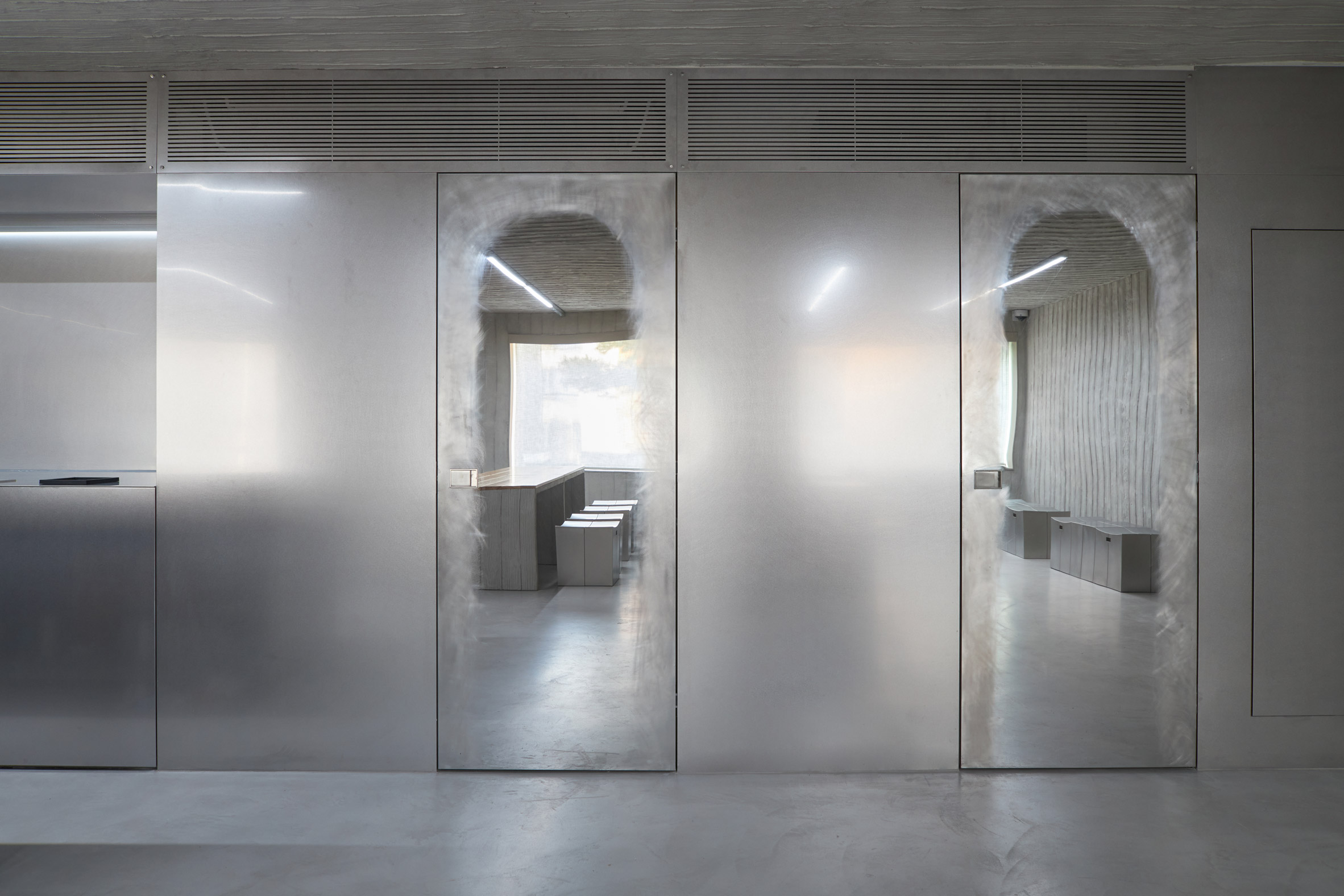 HAHOUSE Cafe by Niceworkshop — HAHOUSE Cafe's threshold reveals the studio's material braiding strategy through a symmetrical composition of two glass-partitioned rooms.