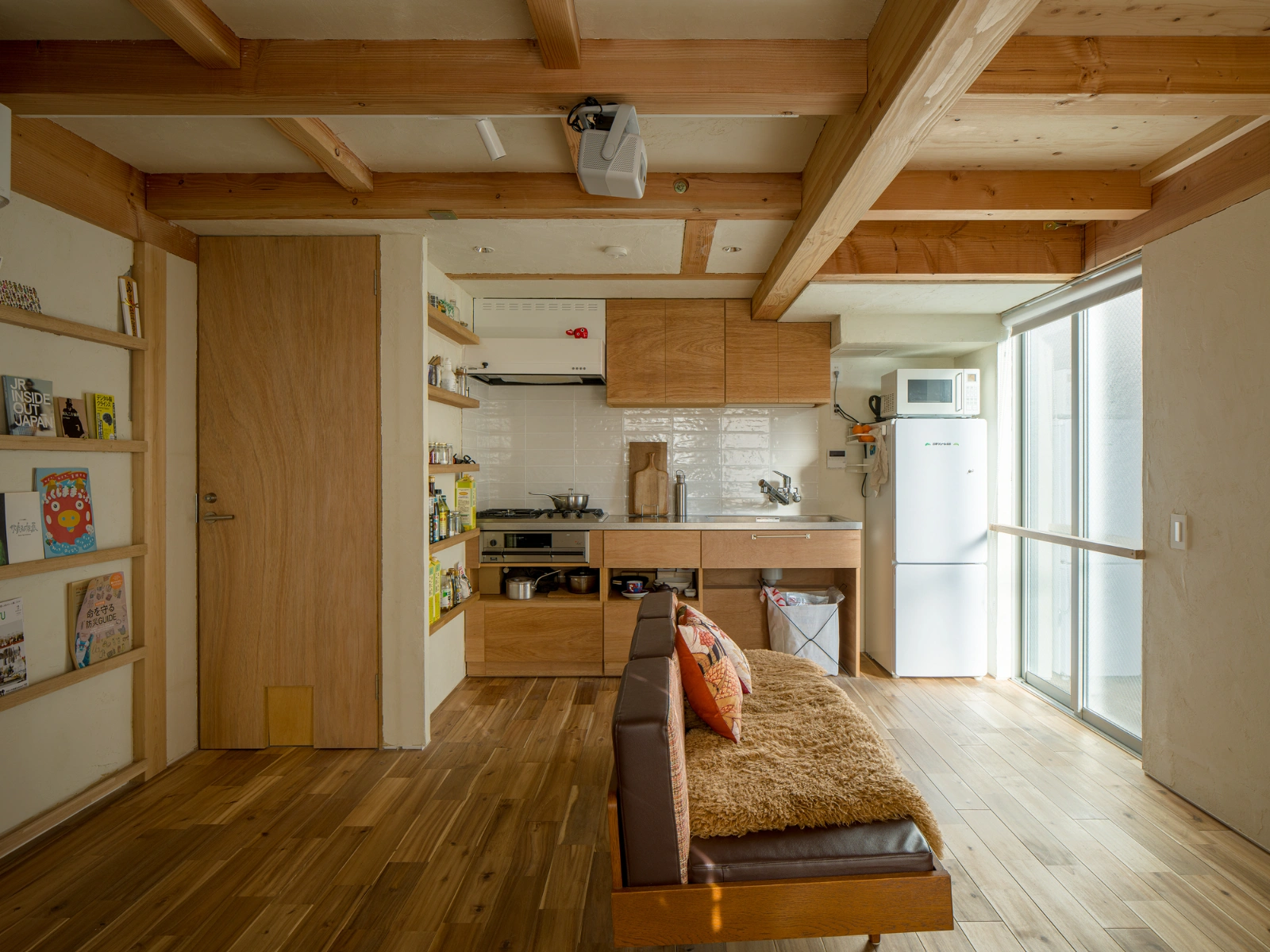 Small House on a Corner Lot by KOMINORU Design — Interior view of a compact 30-square-meter Tokyo residence, demonstrating efficient spatial organization across an open-plan living and kitchen area.