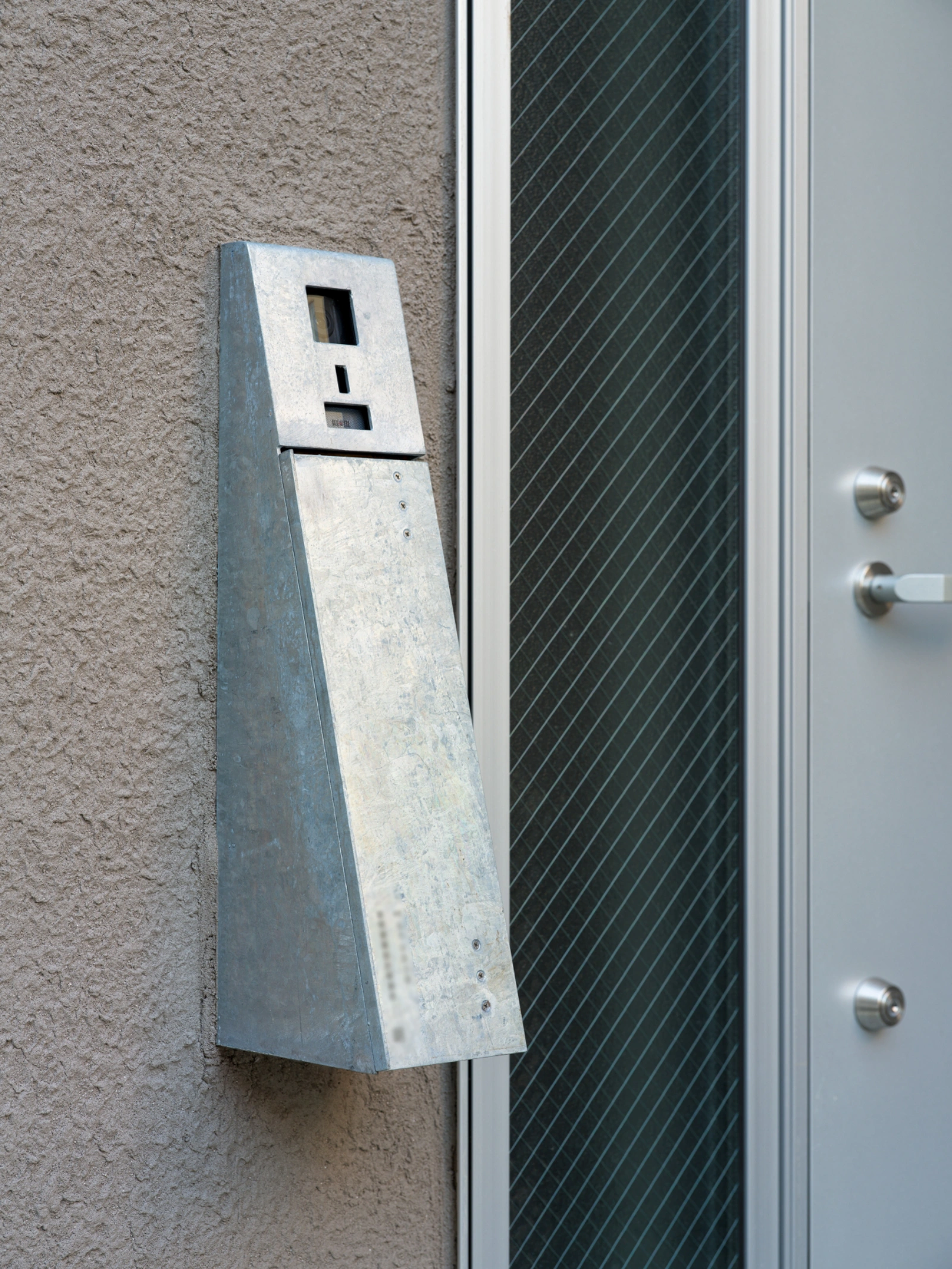 Small House on a Corner Lot by KOMINORU Design — Detail of the corrugated metal utility infrastructure framing the Small House's street-facing facade.