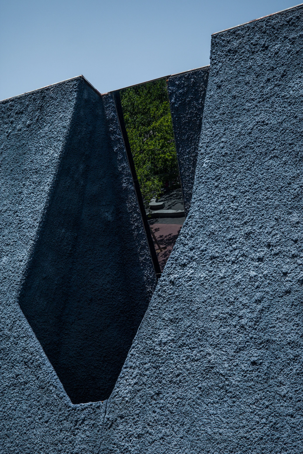 Museu Blau by Herzog & de Meuron — A close-up photograph of the Museu Blau's concrete facade reveals the building's monolithic-cast structure through a narrow, coffin-shaped void.
