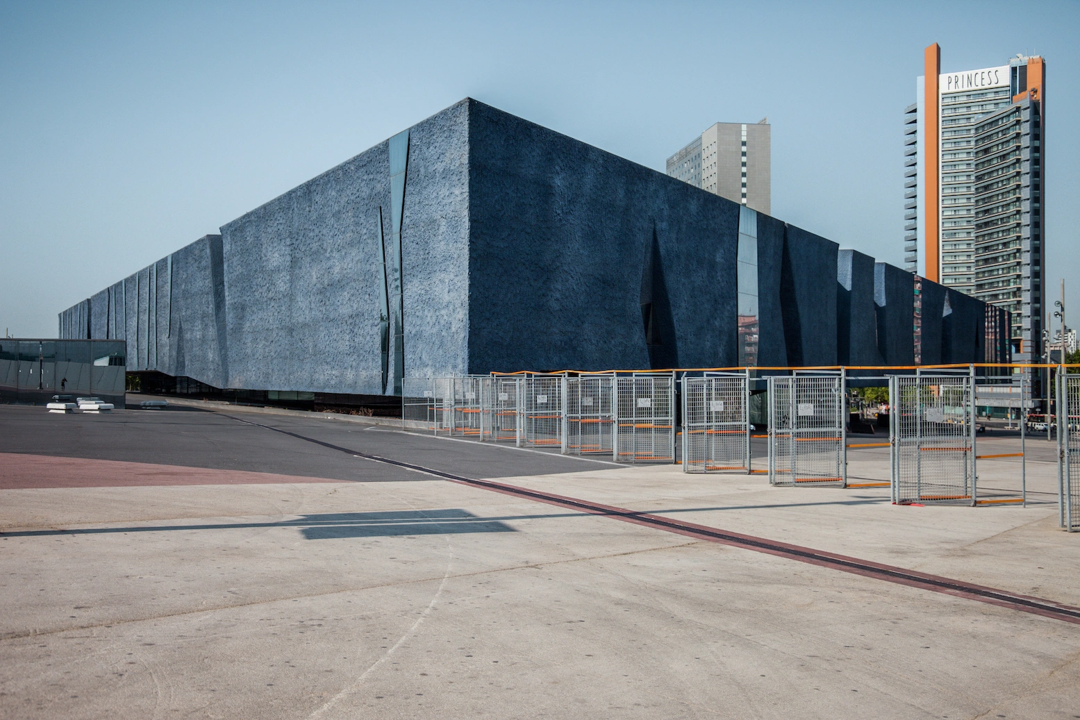 Museu Blau by Herzog & de Meuron — Denis Esakov's photograph captures the Museu Blau's monolithic form from ground level, emphasizing the massive triangular concrete structure's scale against...